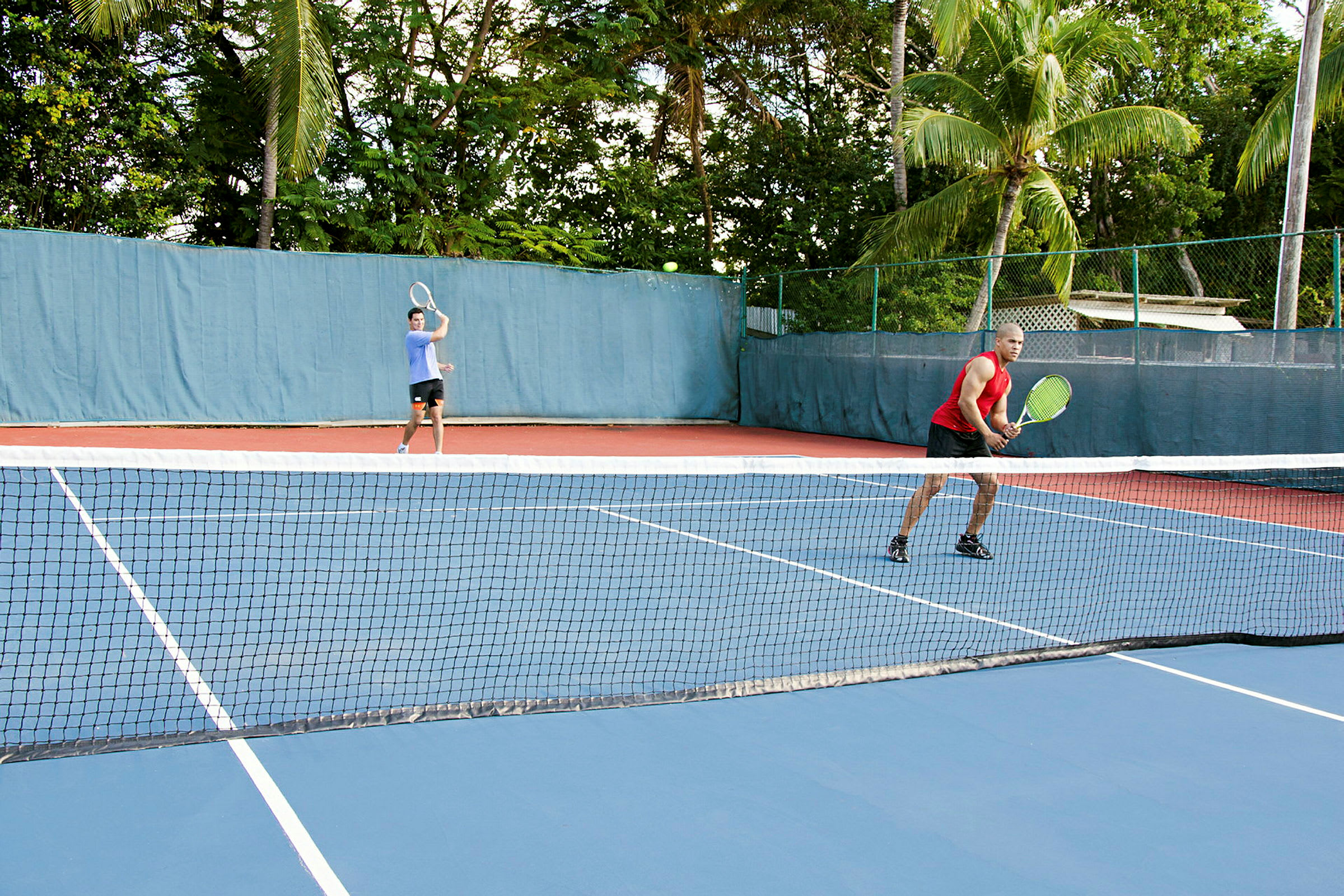 To personer spiller tennis på en utendørsbane. (AI-generert tekst)