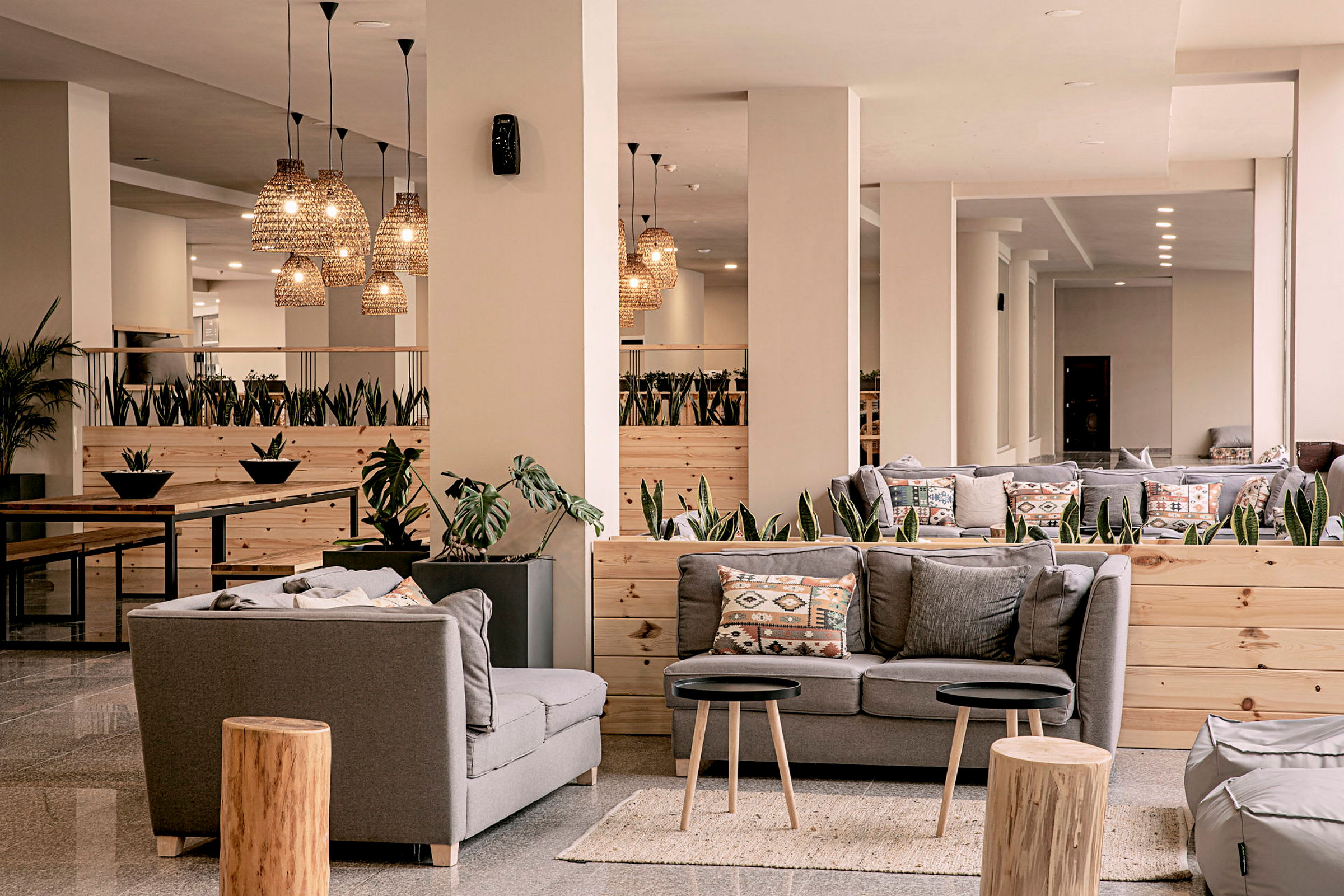 Hotellobby med grå sofaer og dekorativ belysning. (AI-generert tekst)