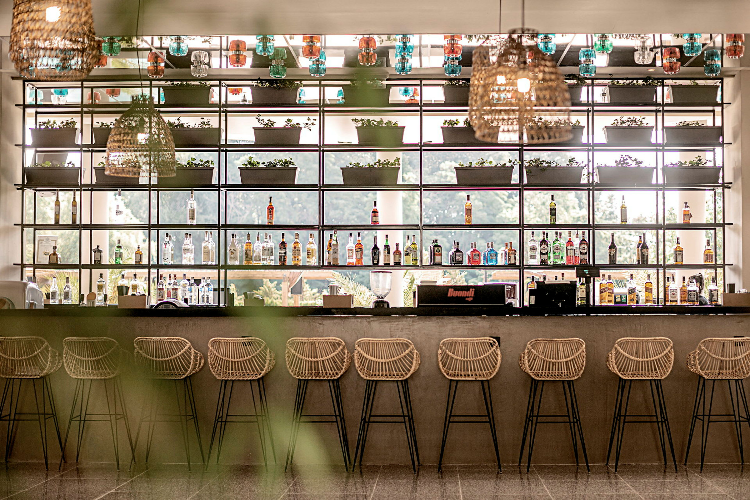 Bilde av en moderne bar med stoler og hyller til dekorasjon. (AI-generert tekst)