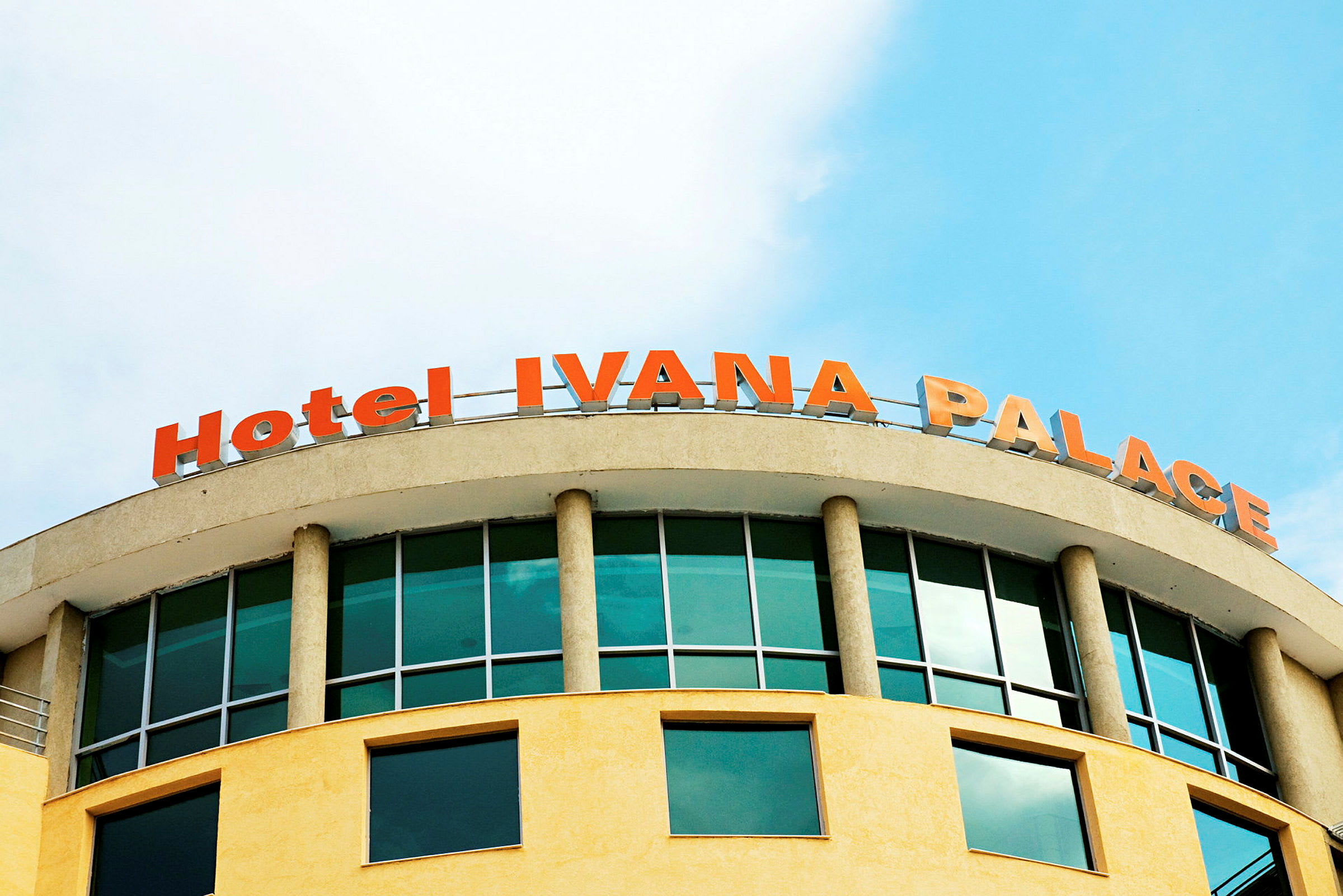 Bilde av en bygning med teksten "Hotel IVANA PALACE" i rødoransje øverst. (AI-generert tekst)