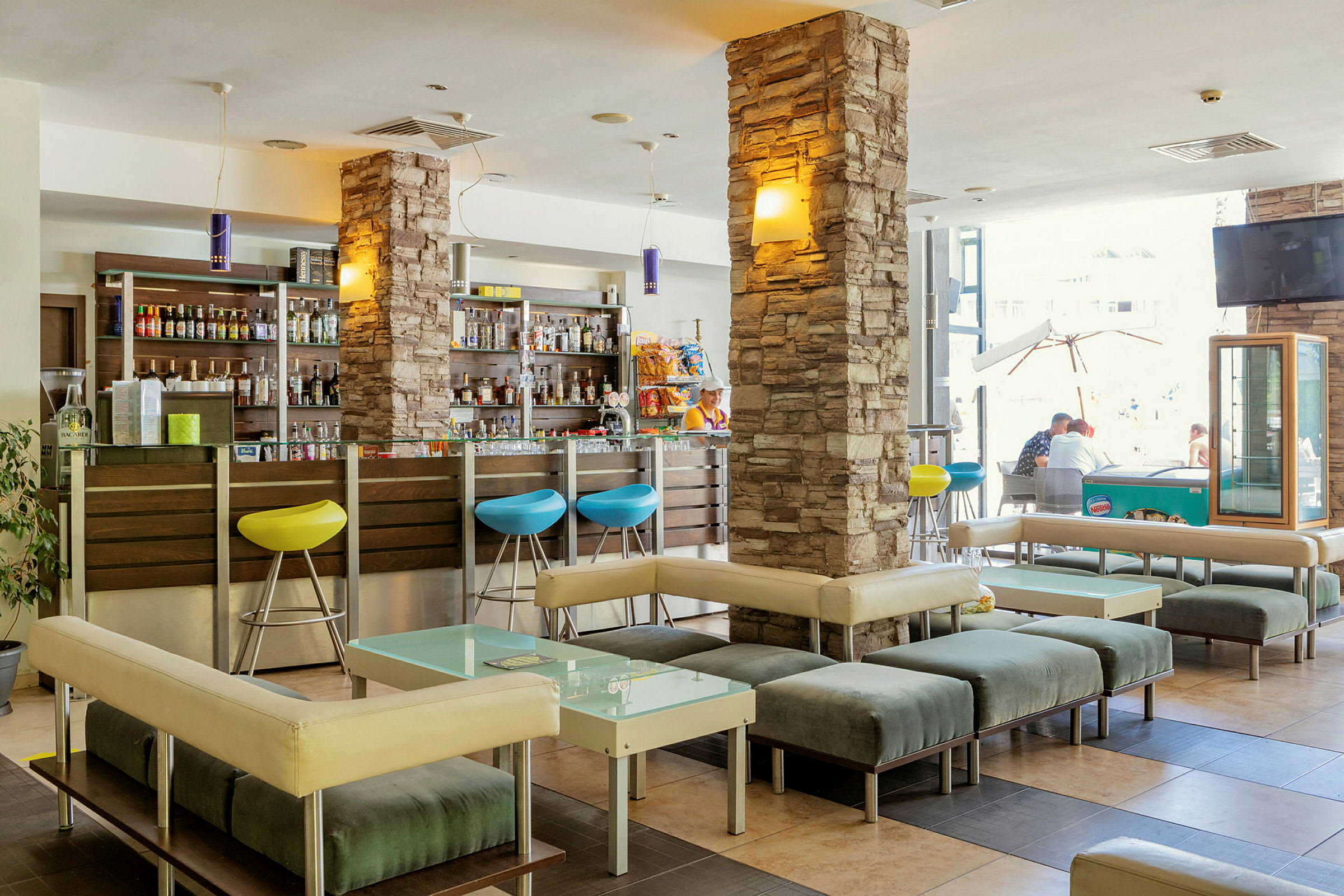 En hotellobby med sitteplasser og en bar. (AI-generert tekst)