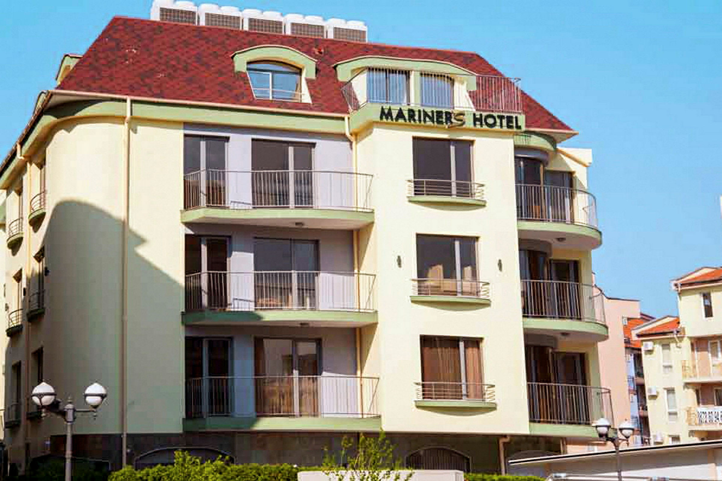Hotel Mariners bygning med flere etasjer og balkonger. (AI-generert tekst)