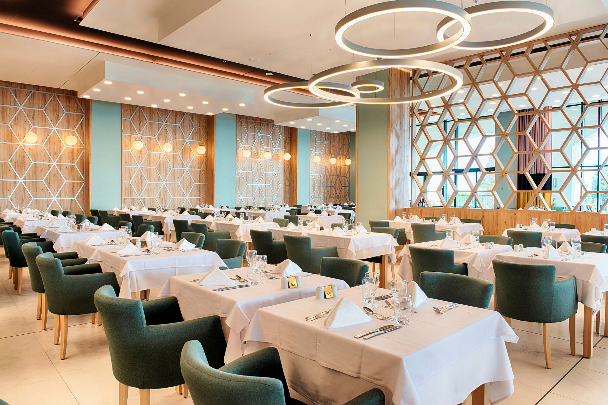 Bilde av en restaurant med dekkede bord og grønne stoler. (AI-generert tekst)