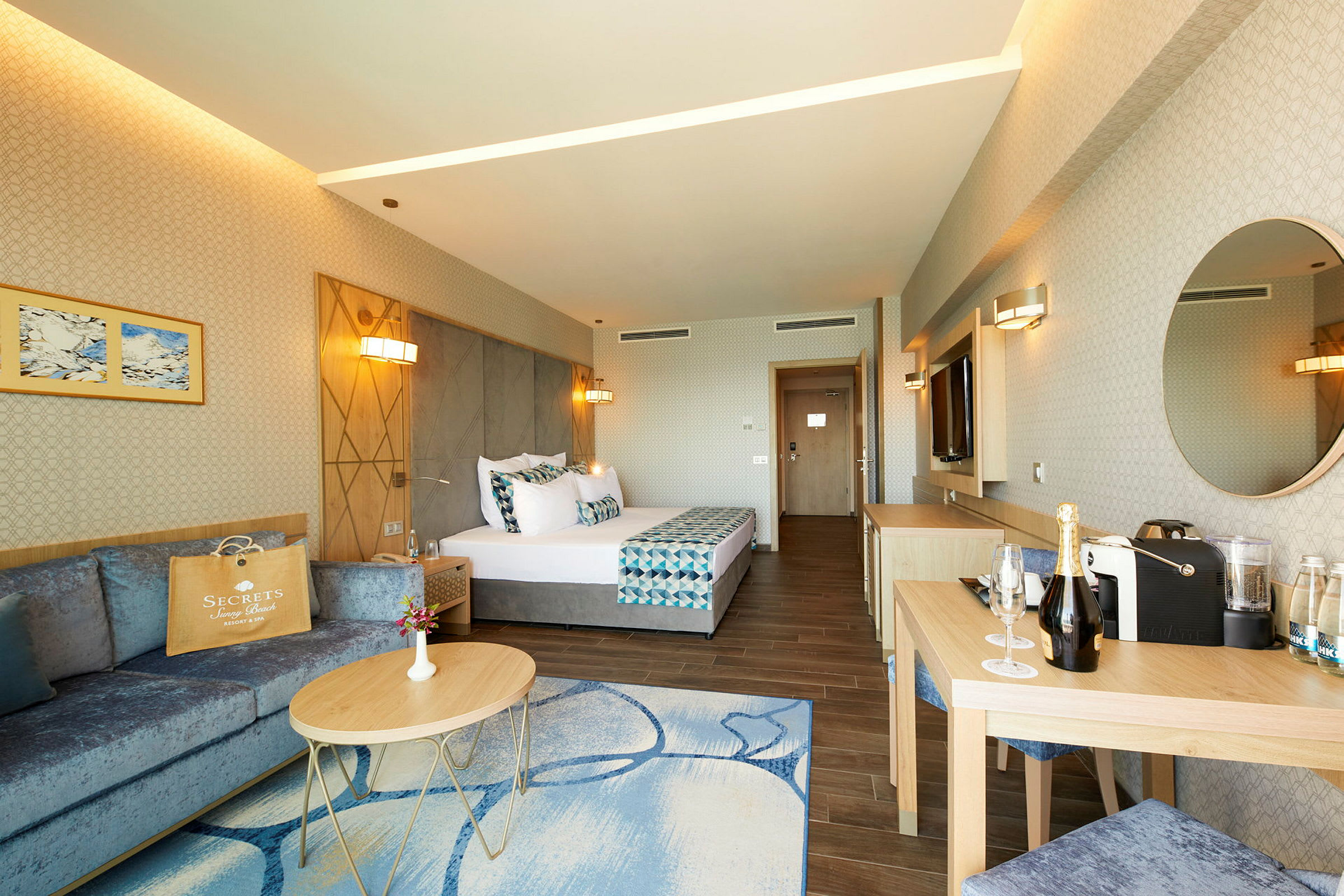 Moderne innredet hotellrom med en dobbeltseng, sittegruppe og skrivebord. (AI-generert tekst)