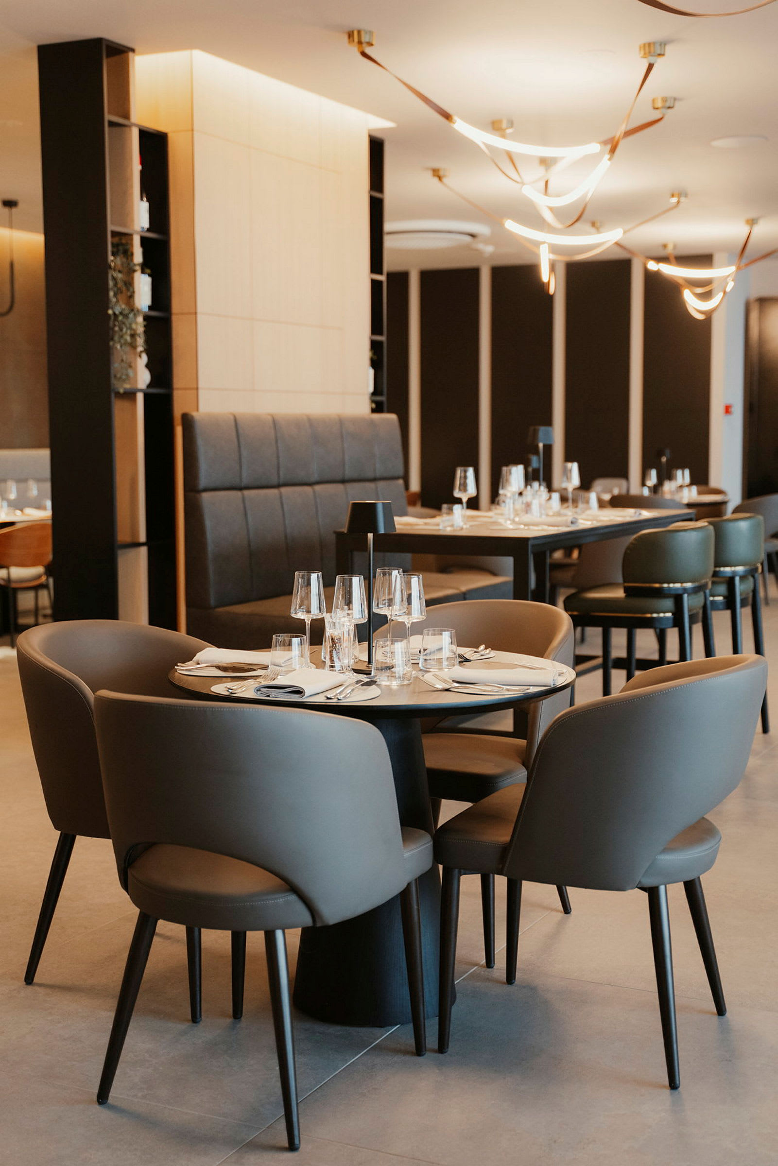 Interiør av en moderne restaurant med dekkede bord og stoler. (AI-generert tekst)