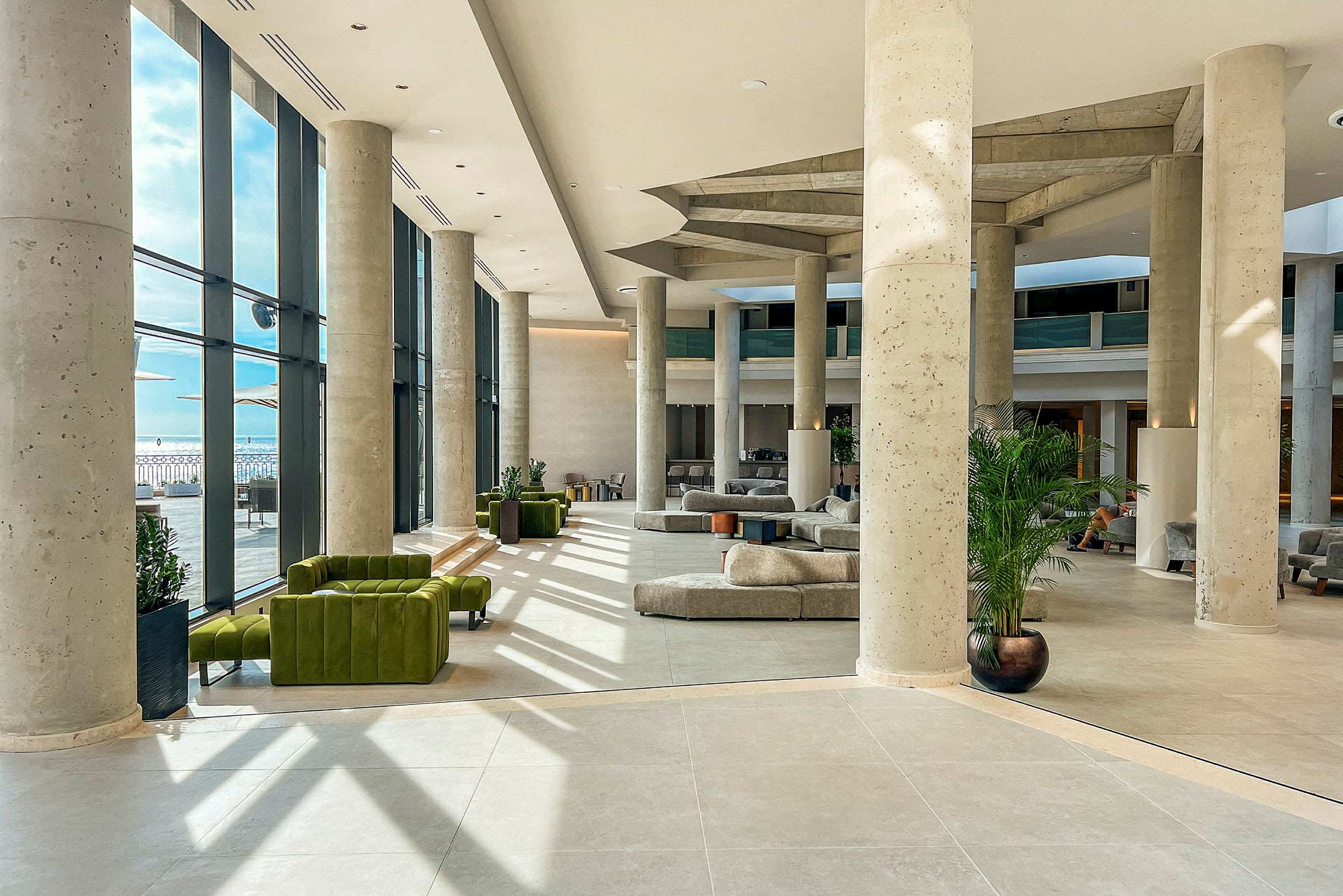 Hotellets moderne lobby med store vinduer og sittemøbler. (AI-generert tekst)