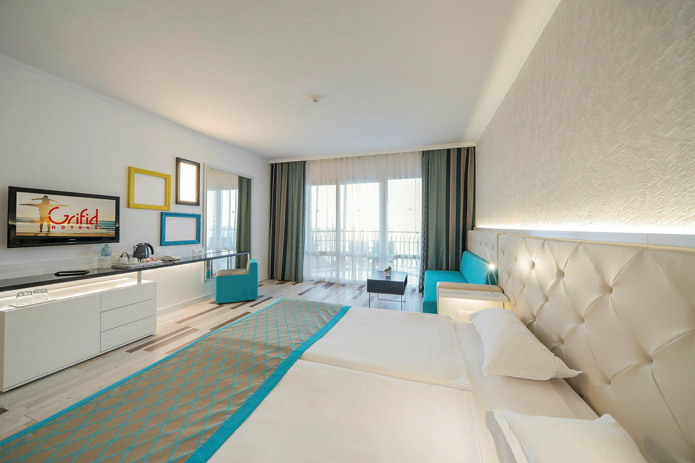 Hotellrom med dobbeltseng, sofa og skrivebord. (AI-generert tekst)
