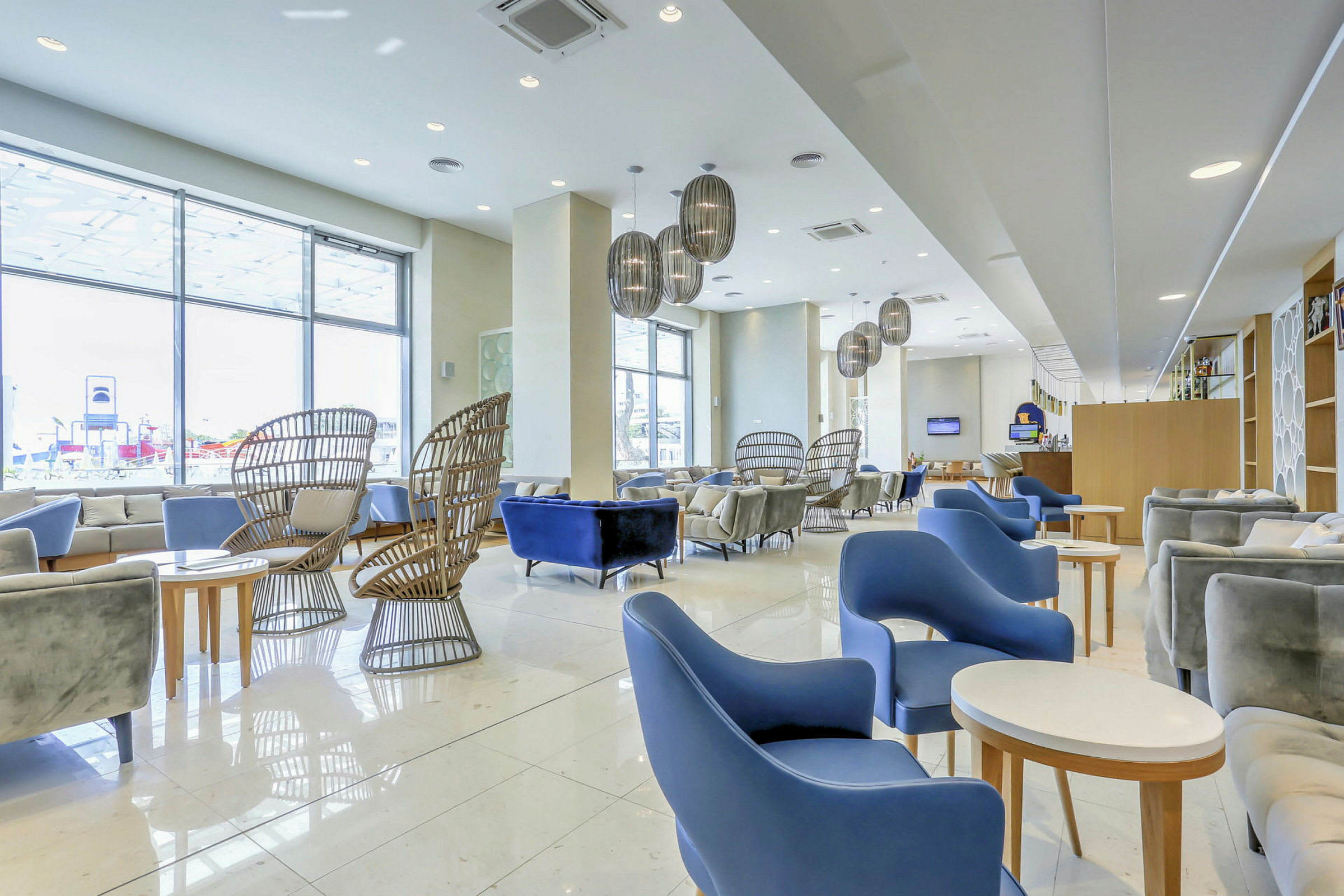 En hotellobby med moderne møbler og store vinduer. (AI-generert tekst)