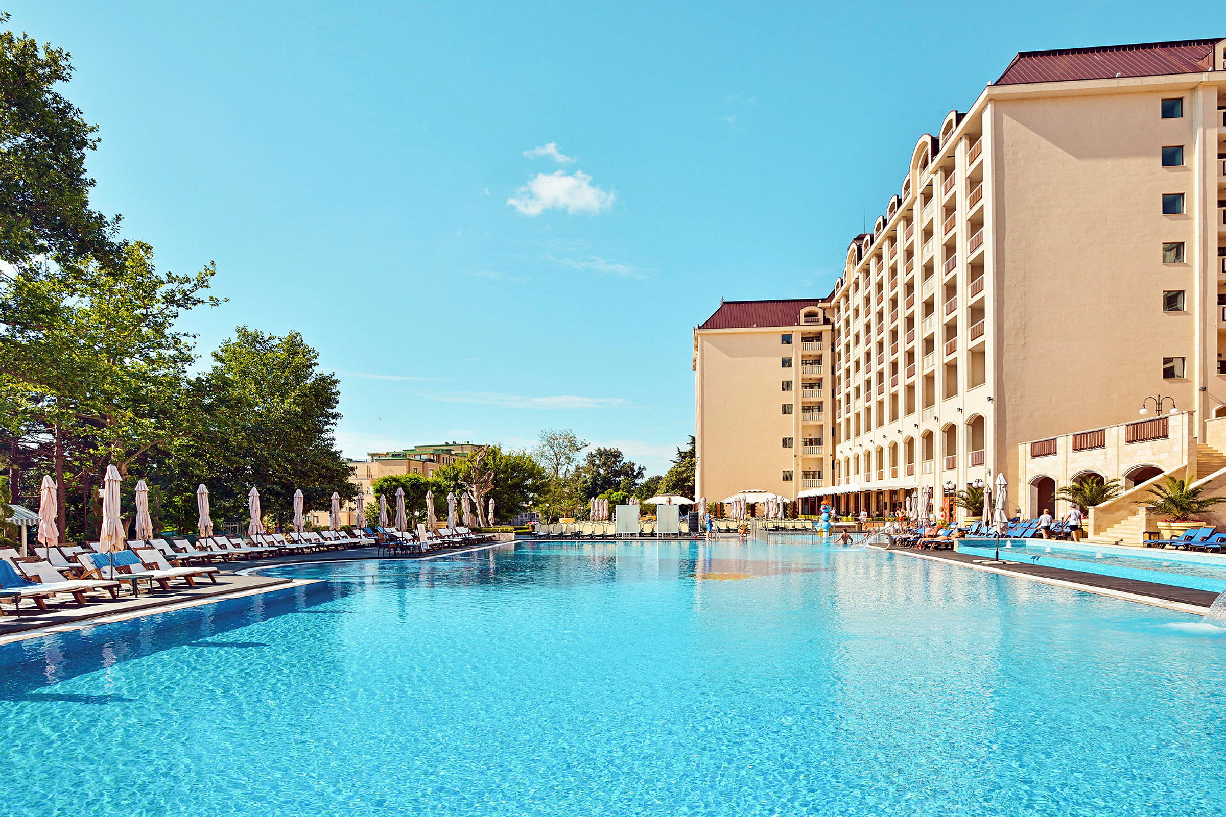 Hotell med basseng og solsenger. (AI-generert tekst)