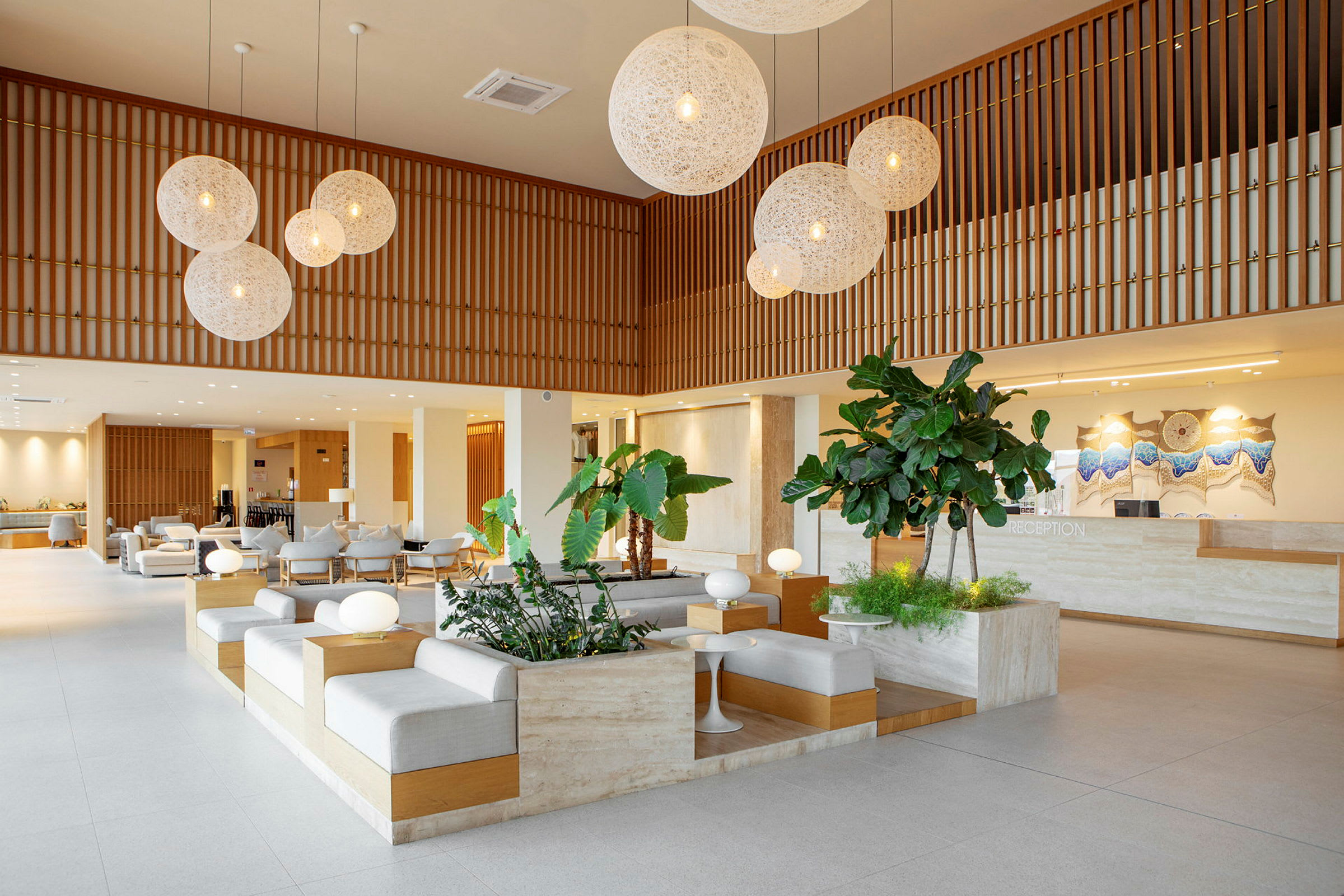Et moderne hotellobbyområde med sitteplasser, planter og en resepsjon. (AI-generert tekst)