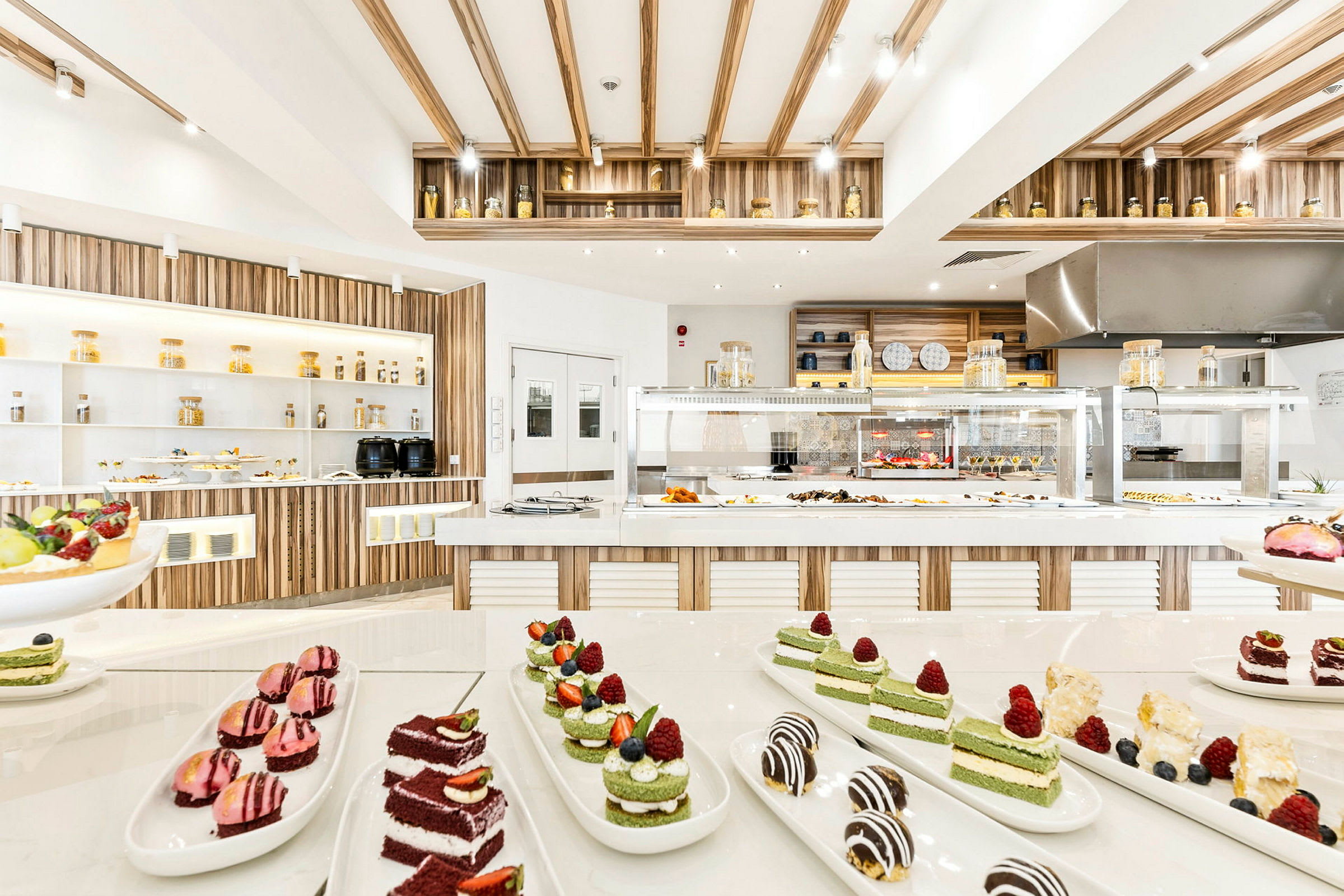 Et moderne og lyst buffetområde med forskjellige desserter og anretninger. (AI-generert tekst)