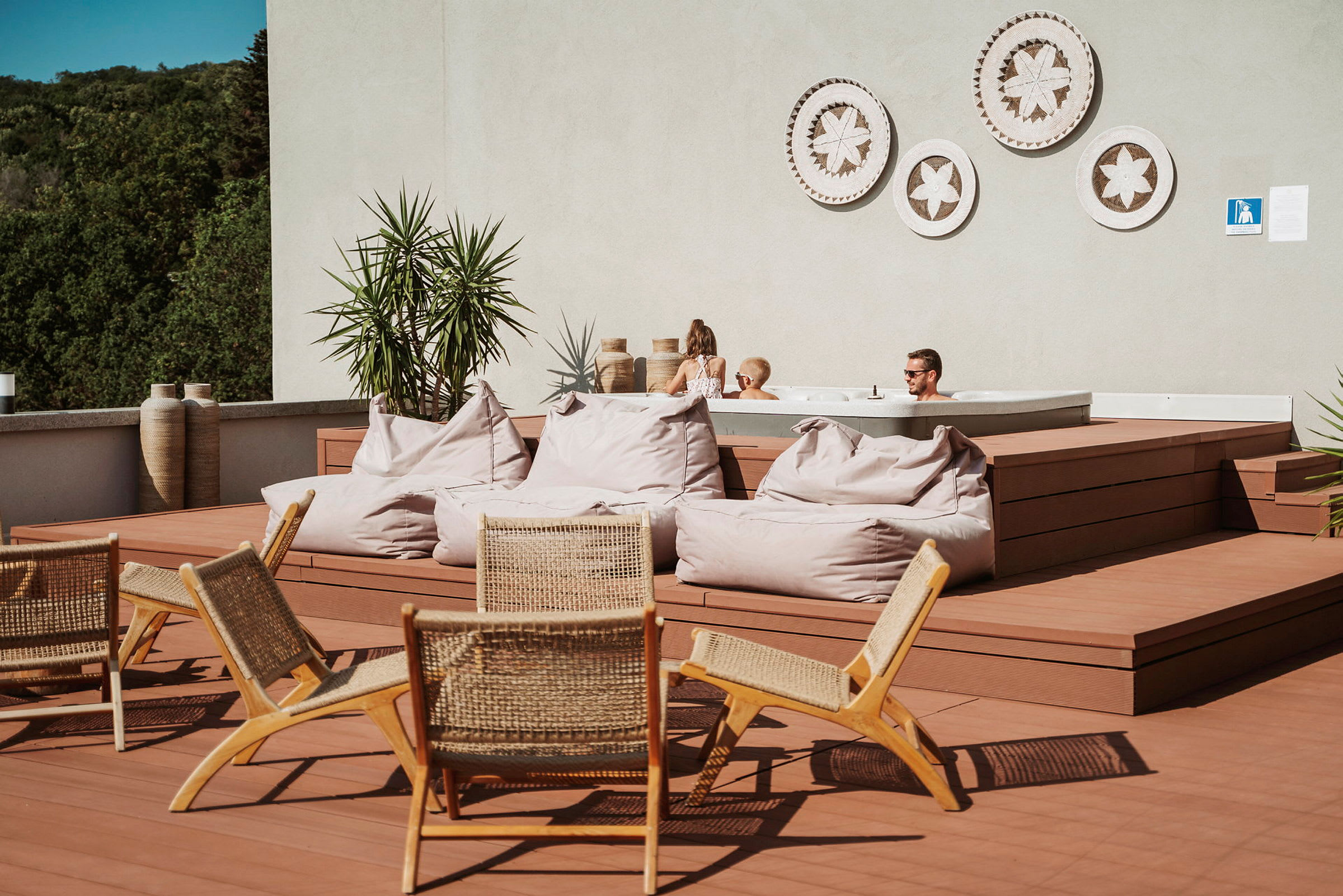 Terrasse med sittemøbler, saccosekker og et boblebad. (AI-generert tekst)