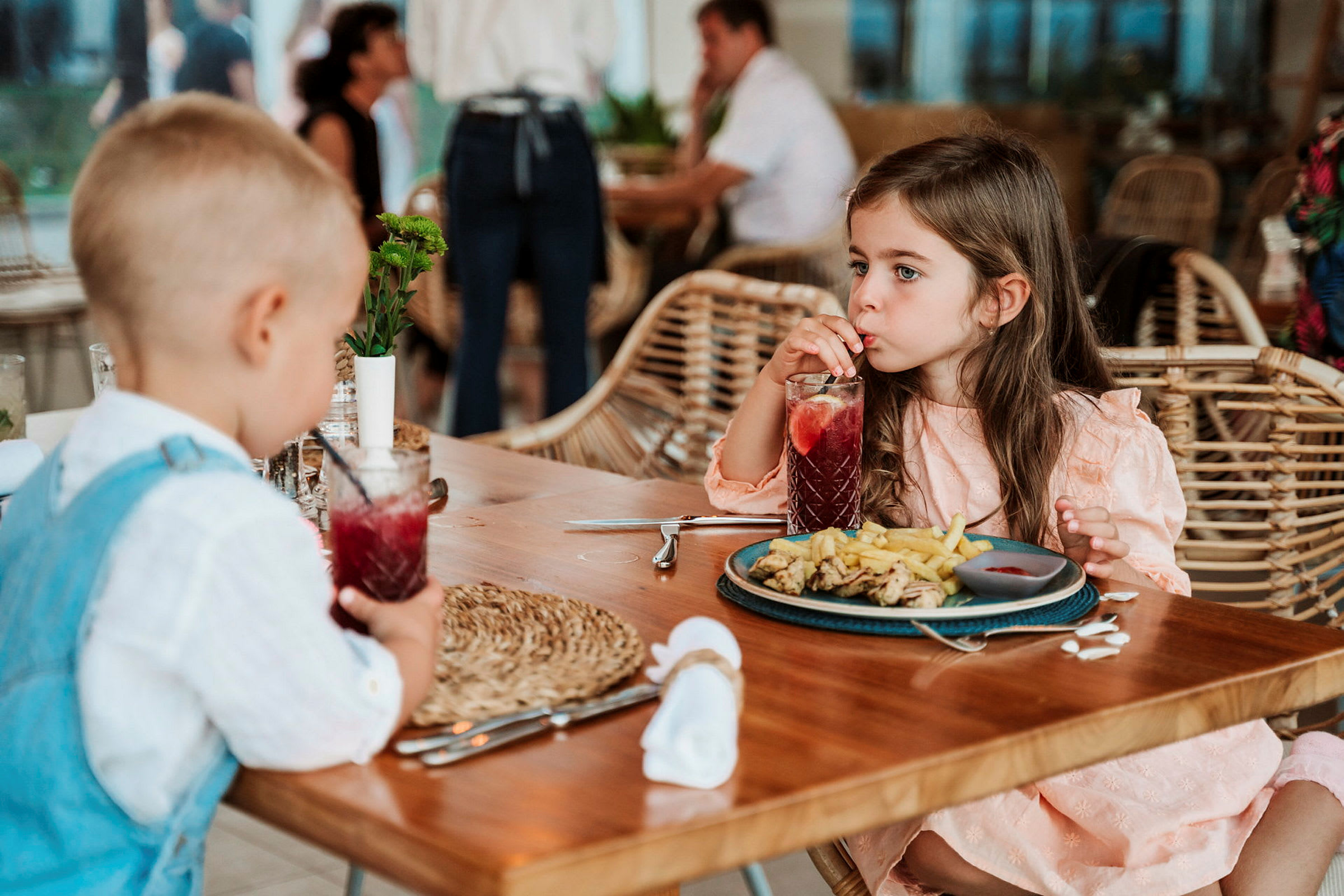 To barn spiser ved et bord på en restaurant. (AI-generert tekst)