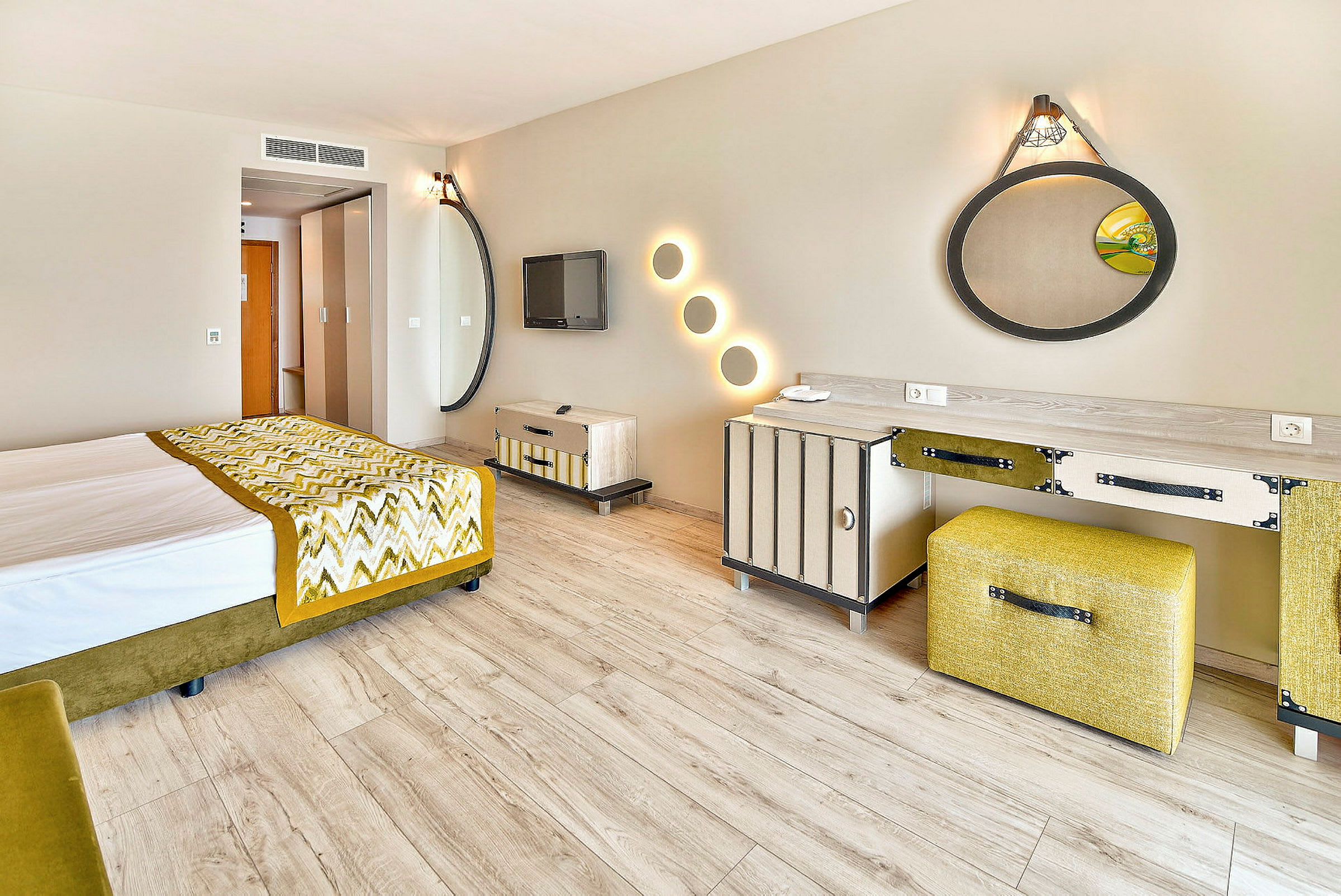 Et hotellrom med moderne innredning, inkludert en seng, speil og et skrivebord. (AI-generert tekst)