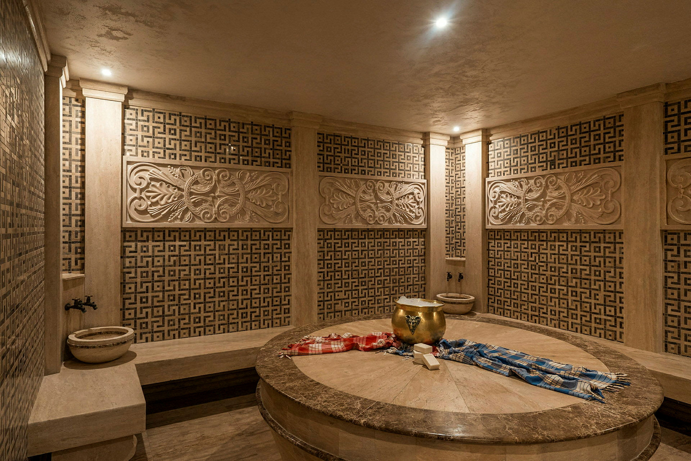 Et tradisjonelt hamam med dekorerte vegger og en sentral steinoverflate. (AI-generert tekst)
