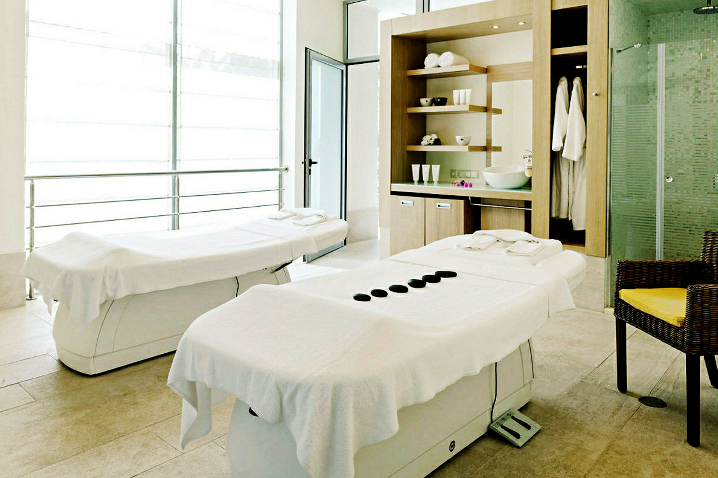 To massasjebord i et lyst rom med spa-innredning. (AI-generert tekst)
