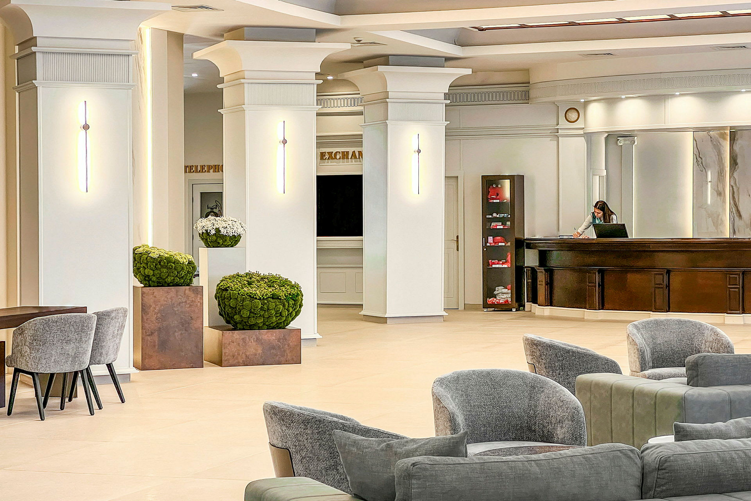 Lys og romslig hotellresepsjon med moderne møbler og stilige veggdetaljer. (AI-generert tekst)