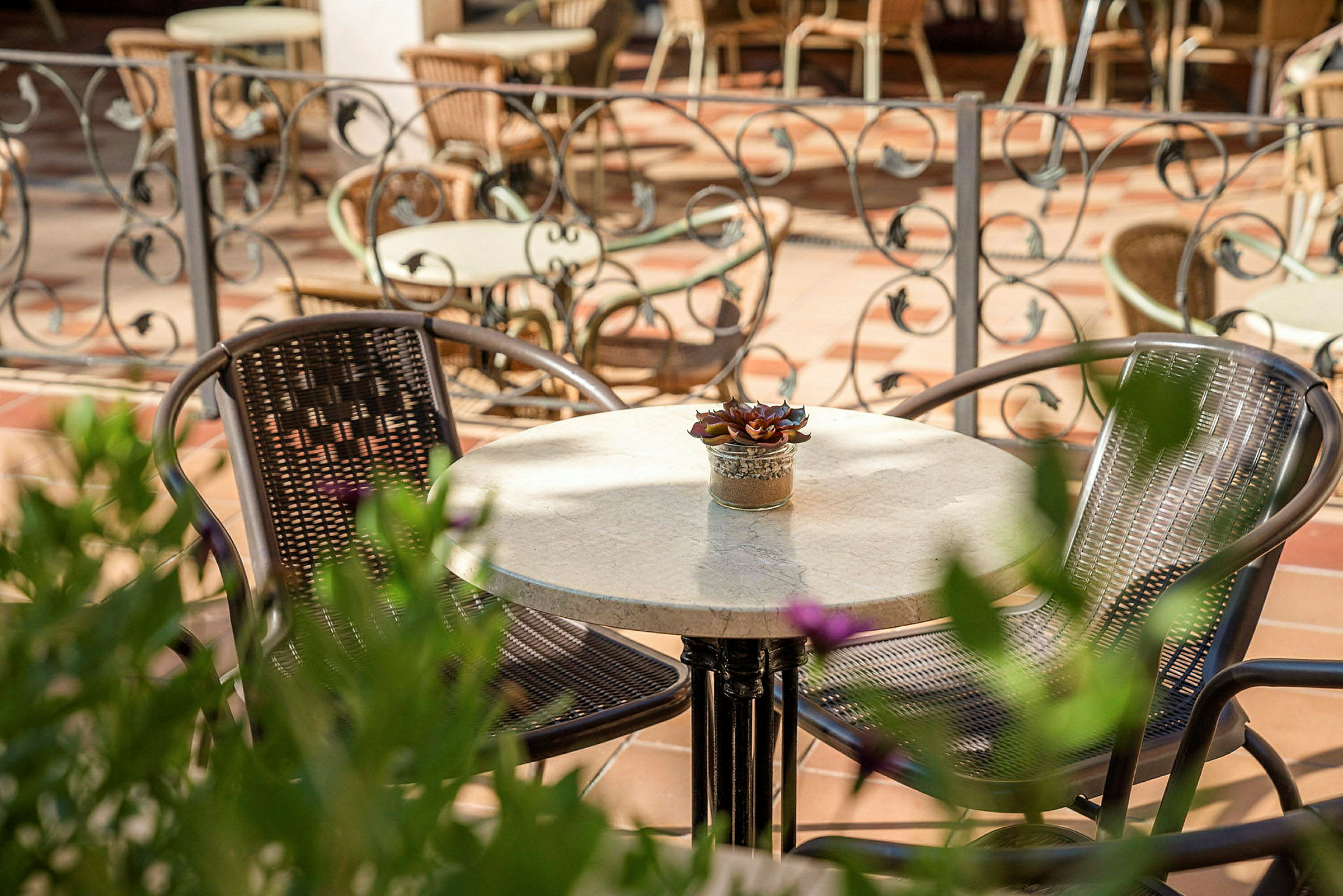 Et bord med to stoler på en terrasse. (AI-generert tekst)