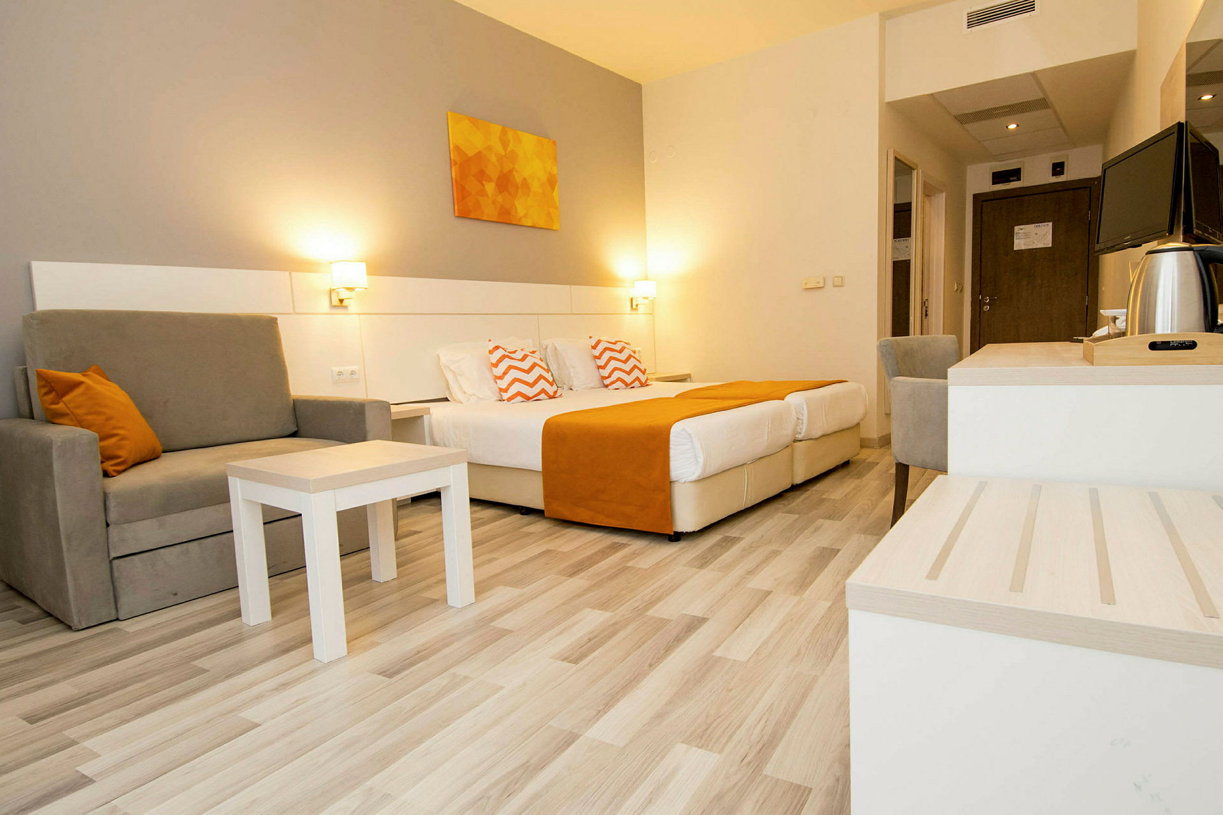 Hotellrom med to senger, sitteplass og skrivebord. (AI-generert tekst)