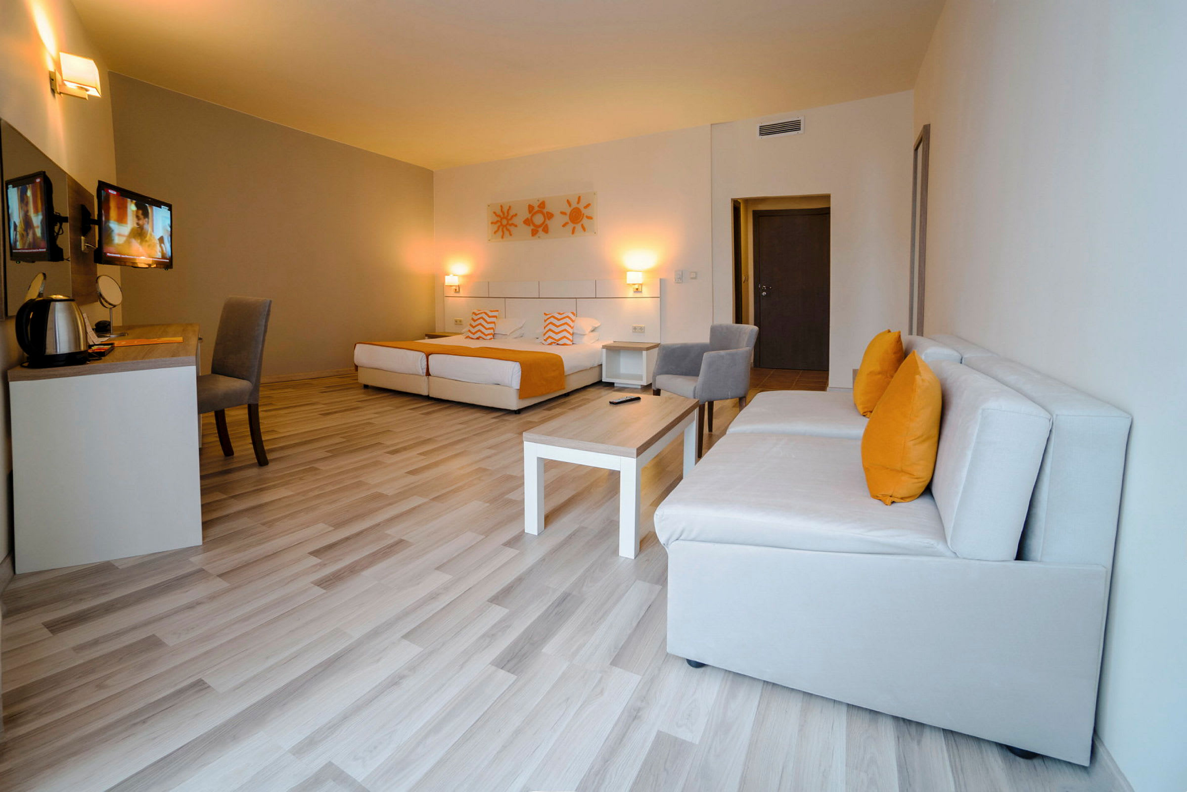 Moderne hotellrom med senger, sofamøbler og skrivebord. (AI-generert tekst)