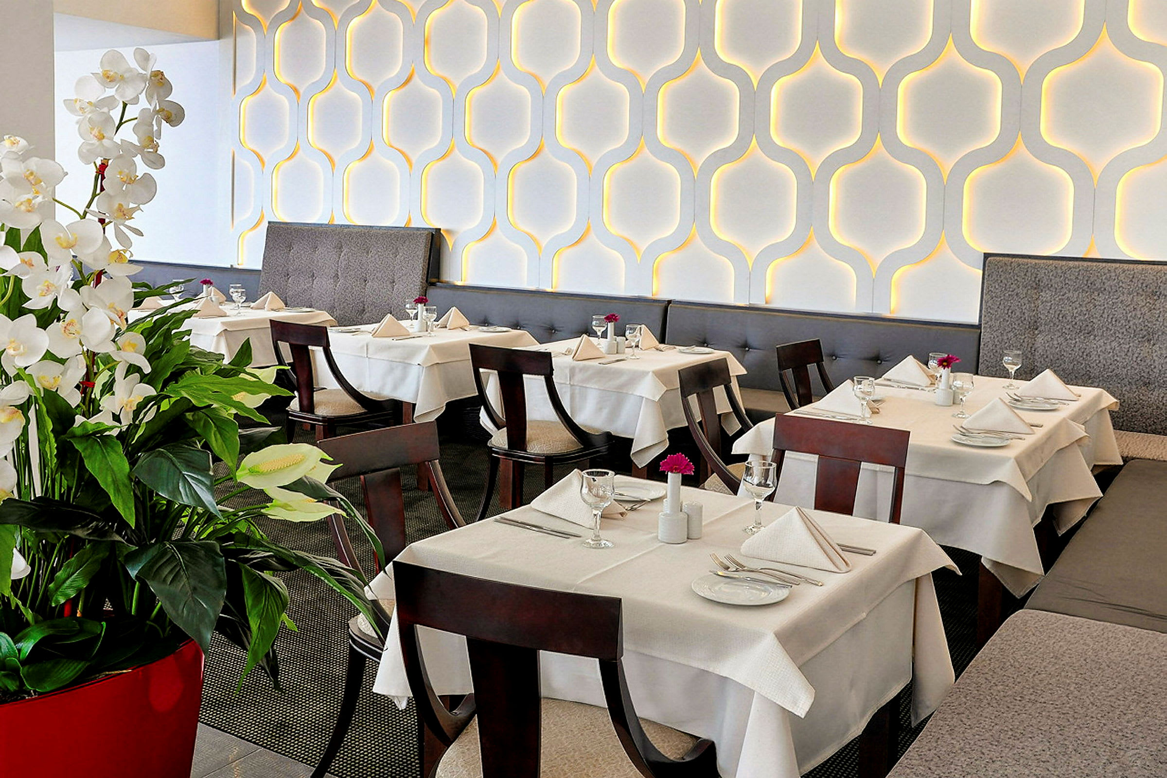 Elegant restaurant med dekkede bord og dekorative hvite blomster. (AI-generert tekst)