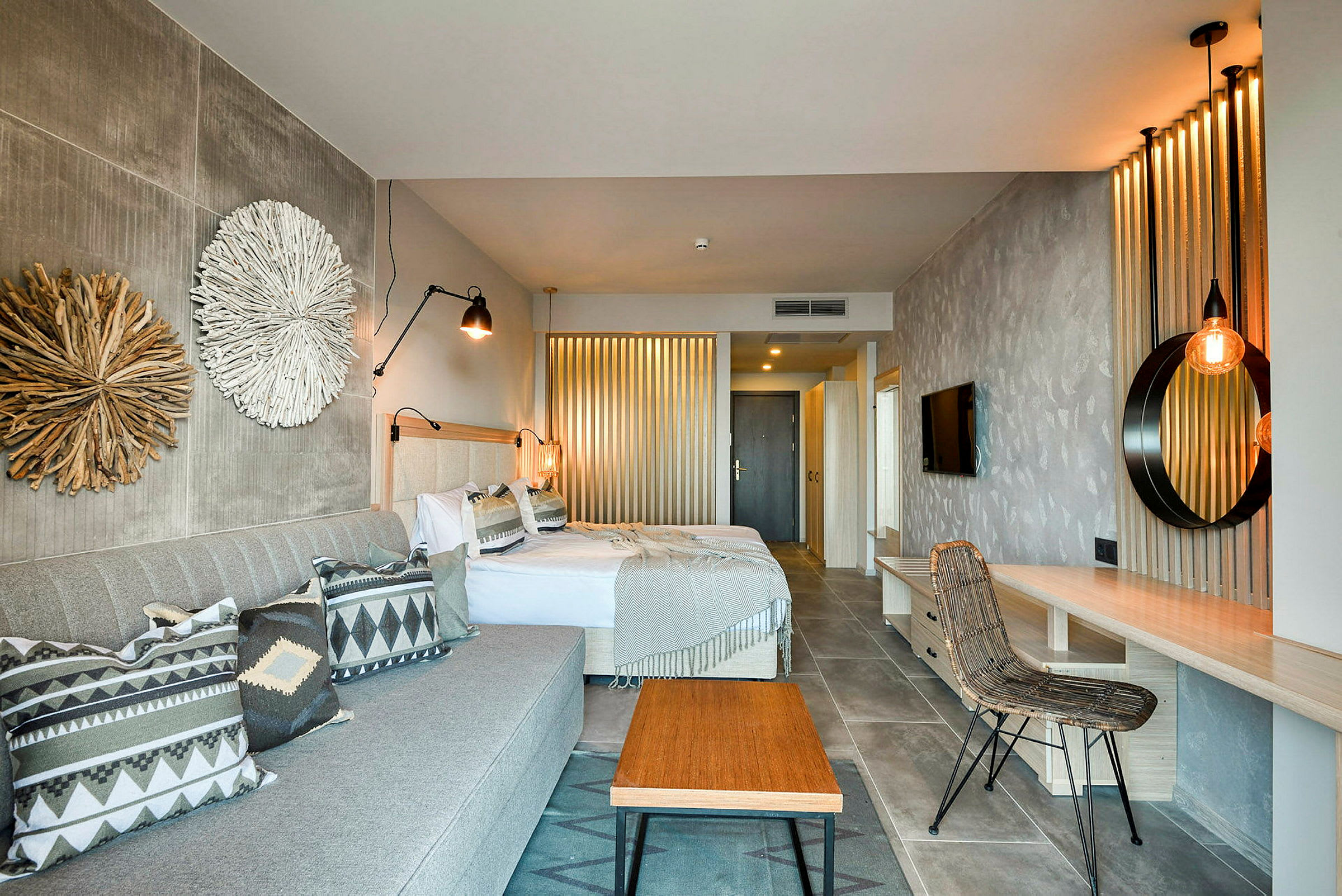 Et hotellrom med to senger, en sofa og interiørdetaljer. (AI-generert tekst)