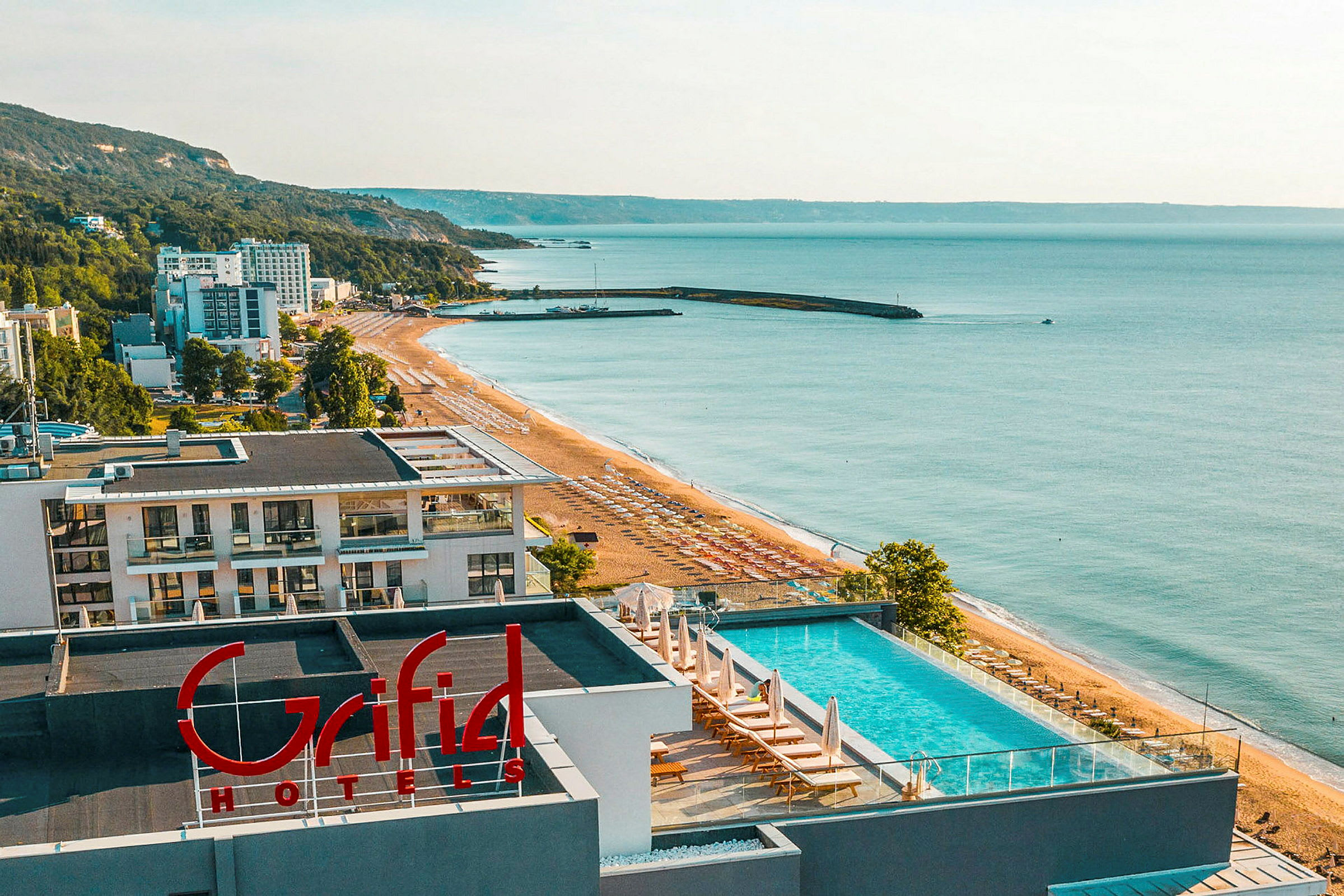 Utsikt over en strand med hotell og hav. (AI-generert tekst)