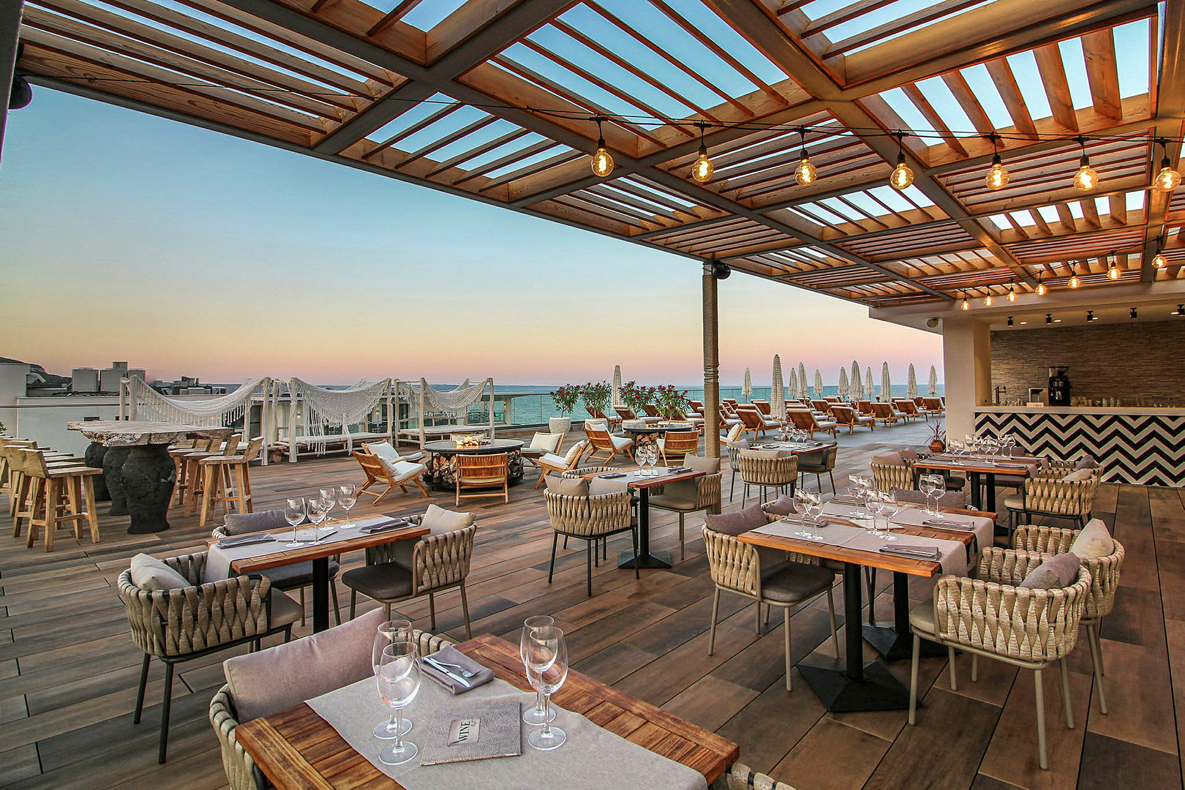 Terrasse med uteservering og solsenger under en trepergola. (AI-generert tekst)