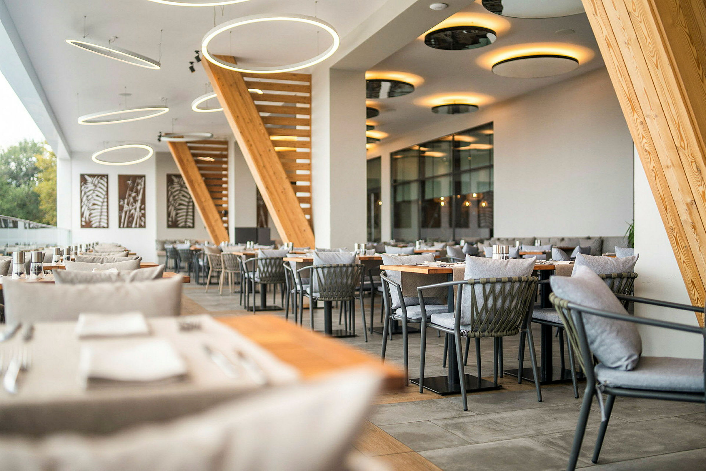 Bilde av en moderne restaurant med elegant interiør, tredetaljer og hengende belysning. (AI-generert tekst)