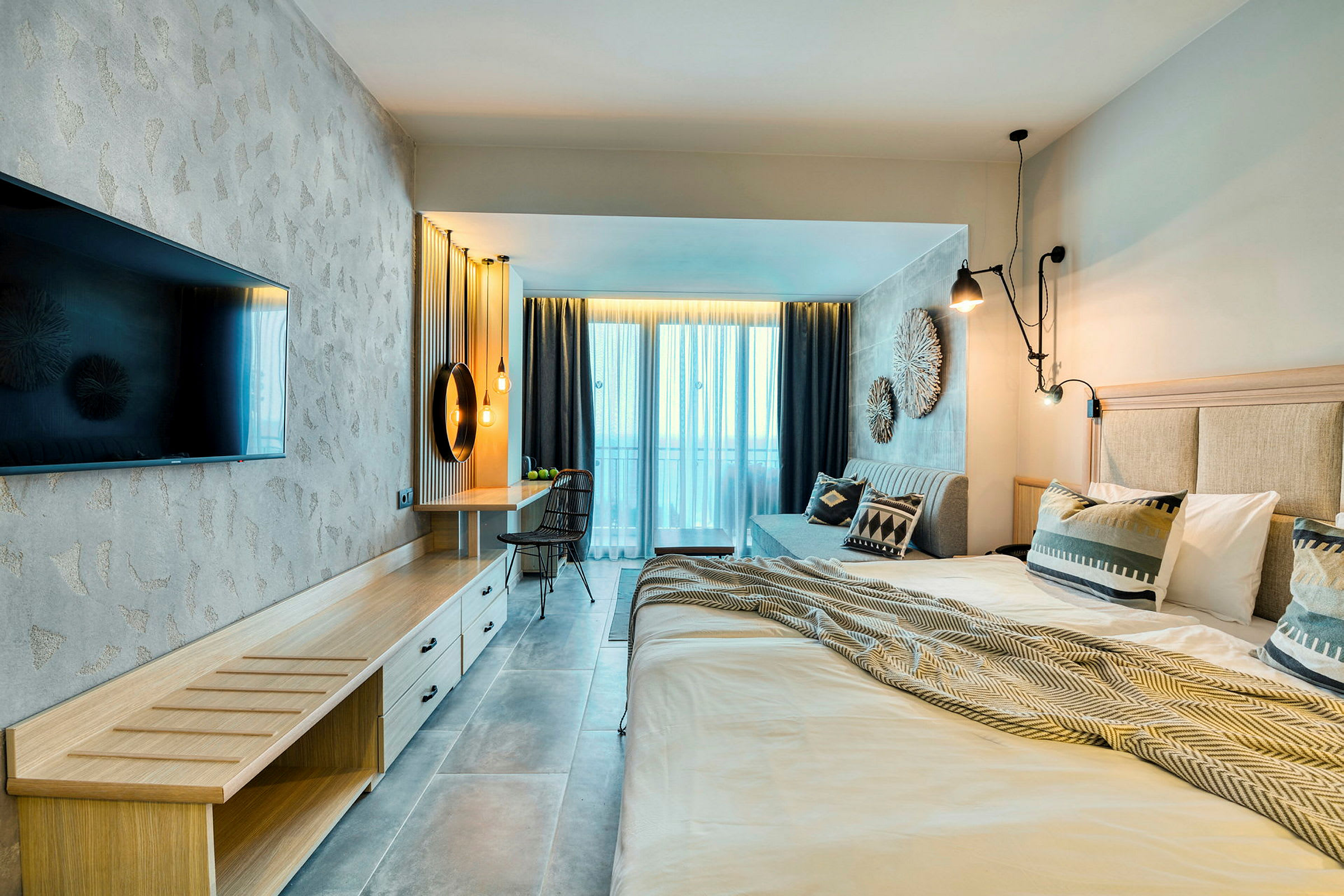 Moderne hotellrom med dobbeltseng, TV, skrivebord og balkong. (AI-generert tekst)