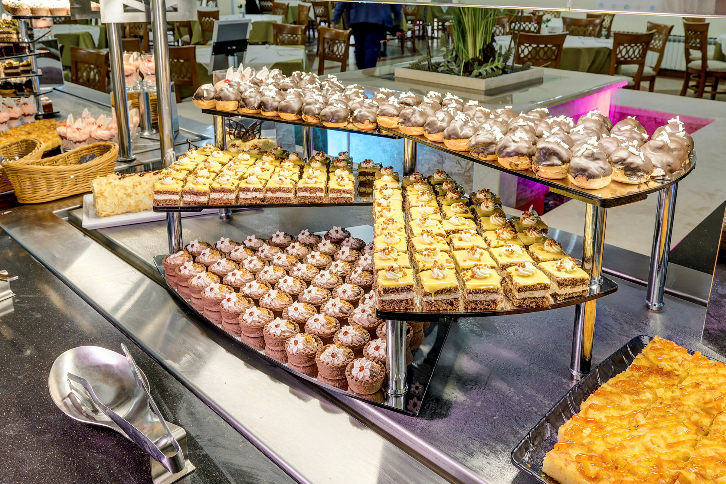 Et dessertbord med et utvalg av ulike bakverk og kaker på et serveringsstativ. (AI-generert tekst)