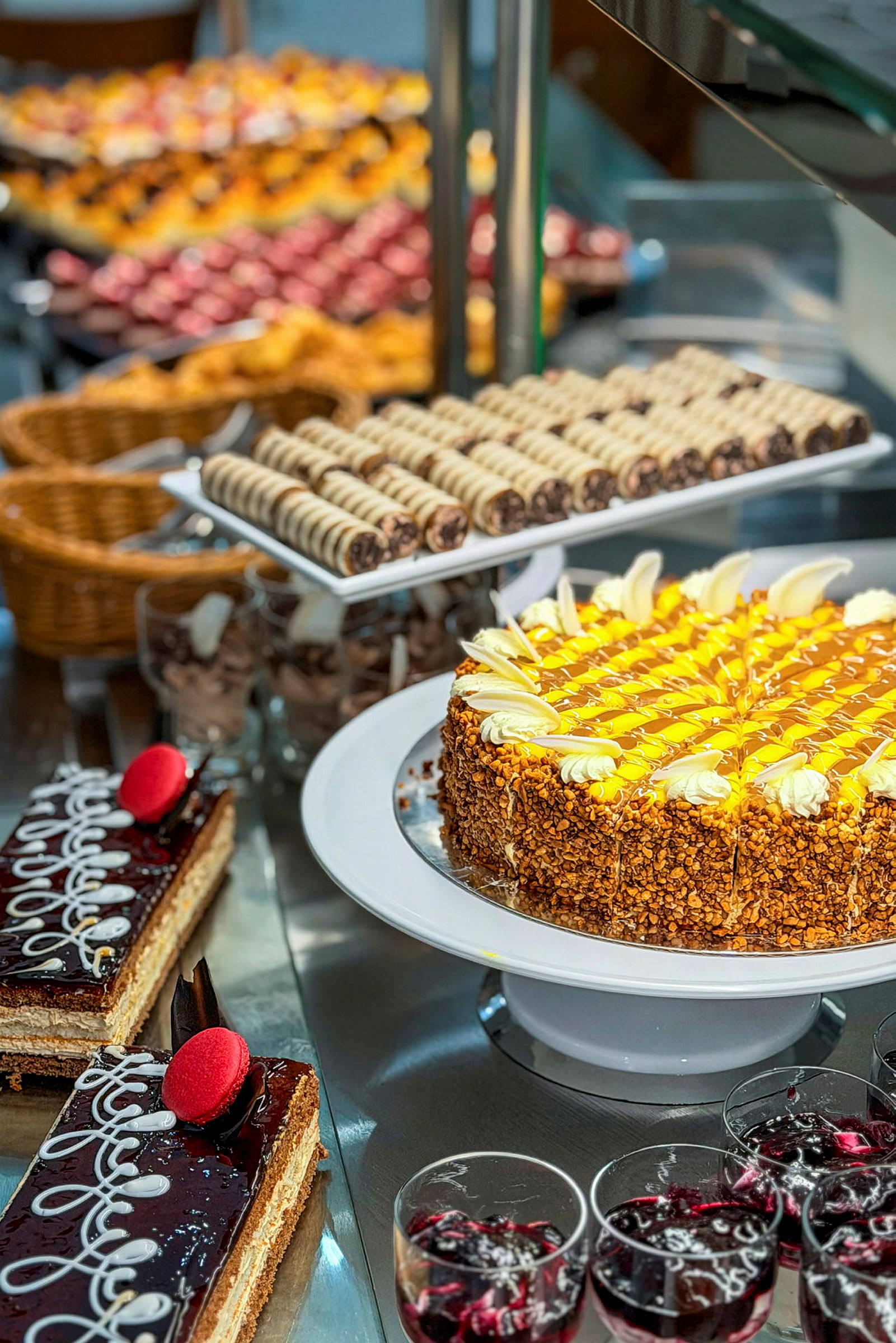 Et bord med ulike desserter, inkludert en kake dekorert med gul glasur og godbiter. (AI-generert tekst)