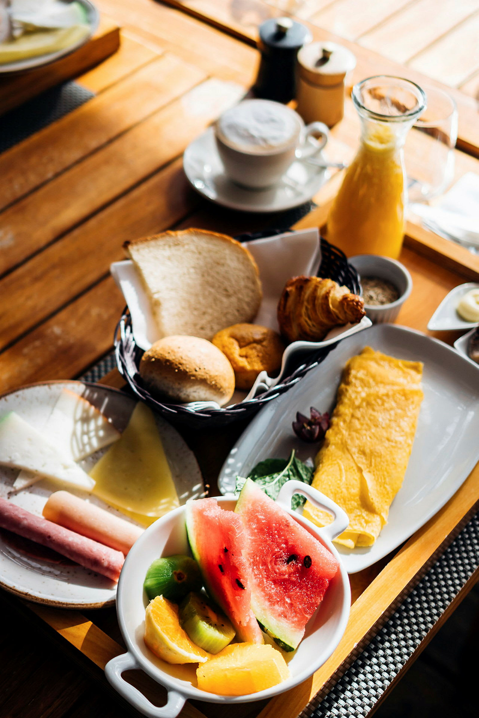 En frokosttallerken med omelett, frukt, brød og kaffe. (AI-generert tekst)