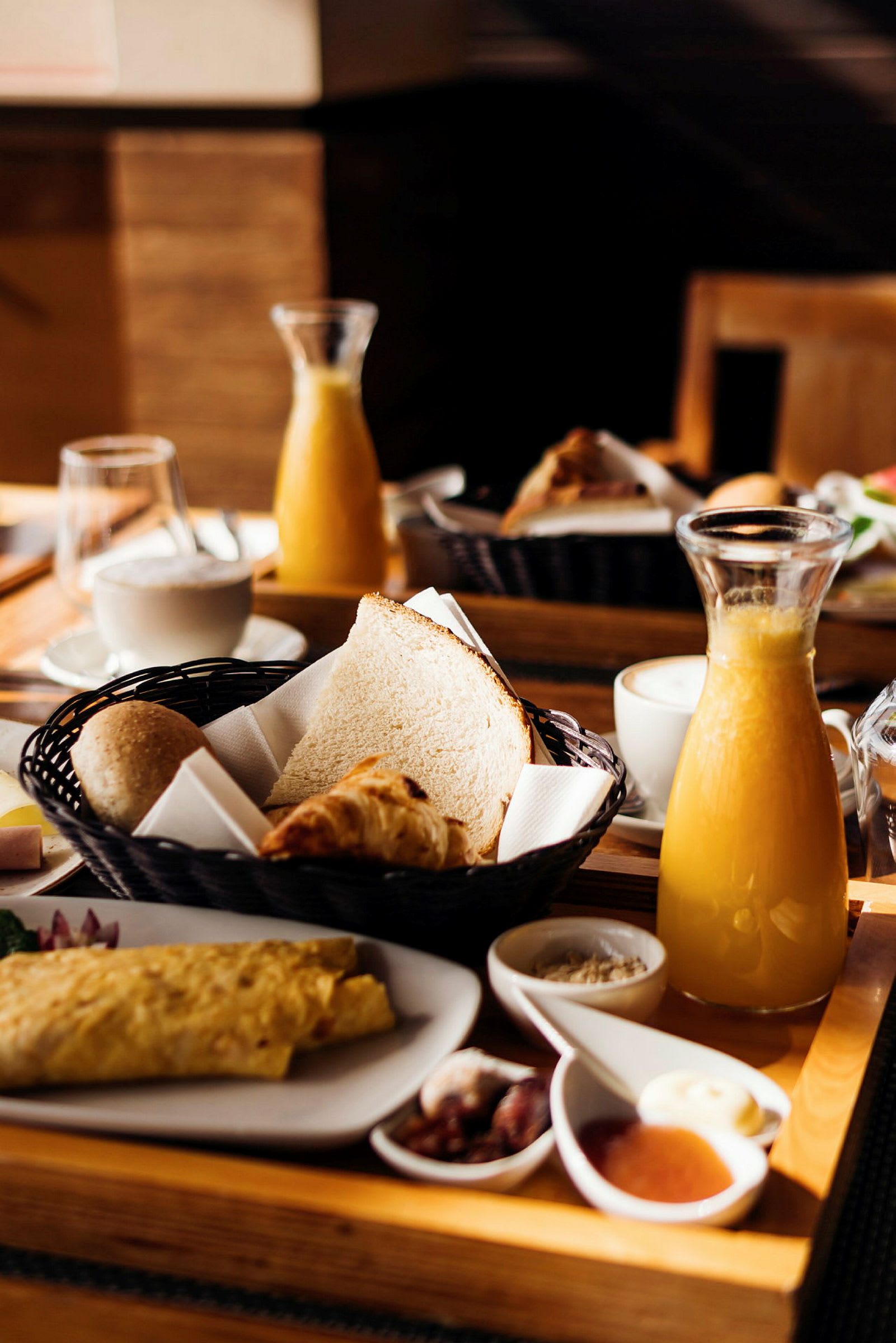 Bilde av en frokost med brød, croissant, juice og kaffe. (AI-generert tekst)
