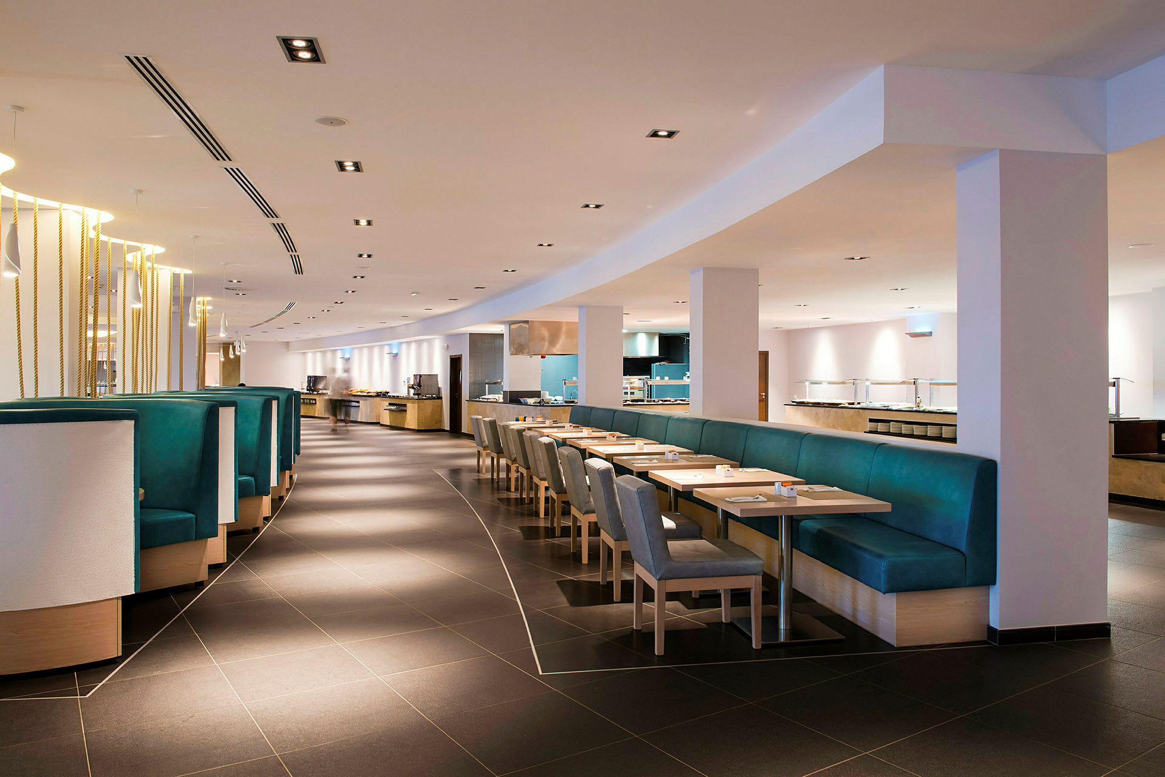 Bilde av et moderne restaurantmiljø med bord, stoler og benker. (AI-generert tekst)