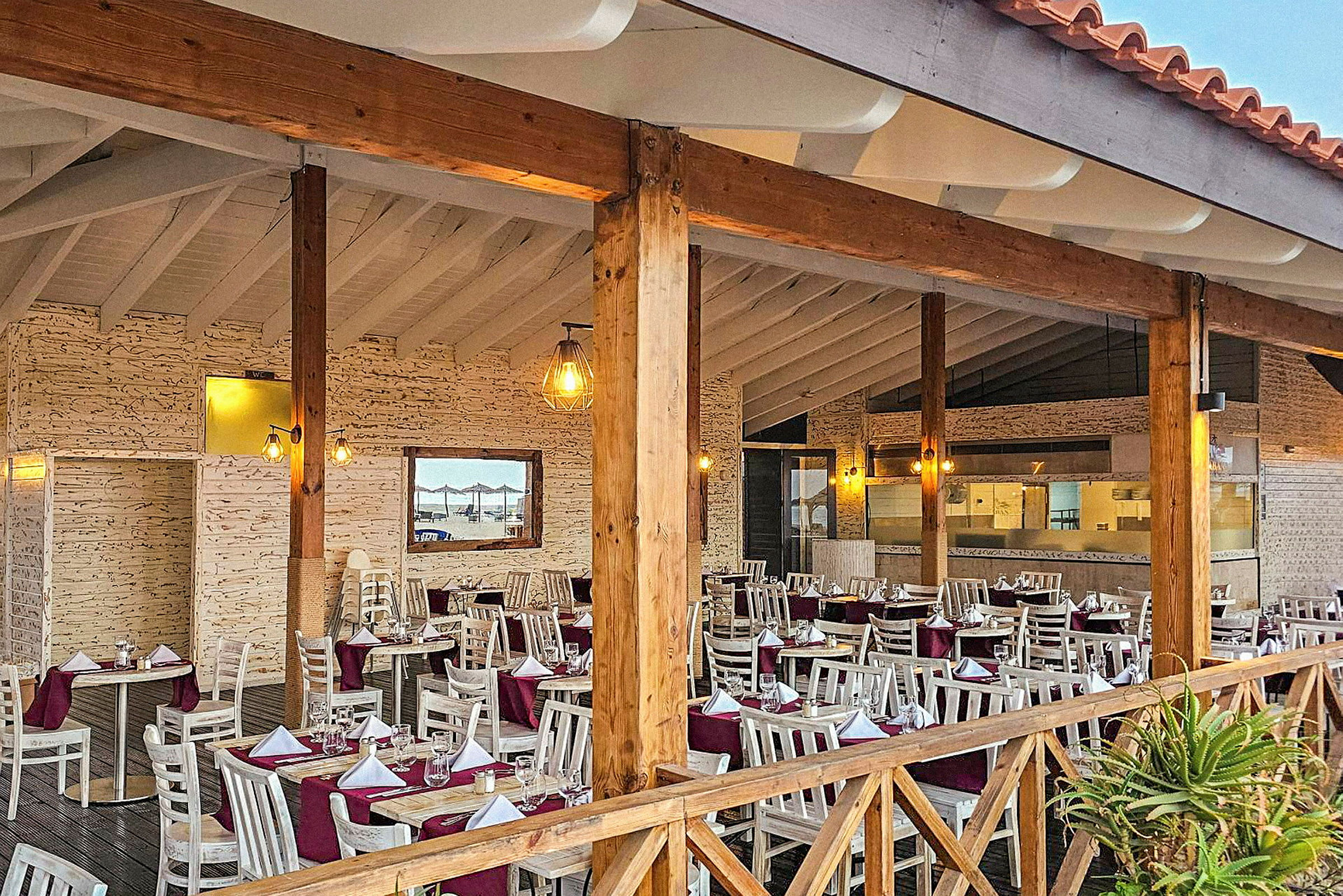 En restaurant med dekkede bord og trestolper. (AI-generert tekst)