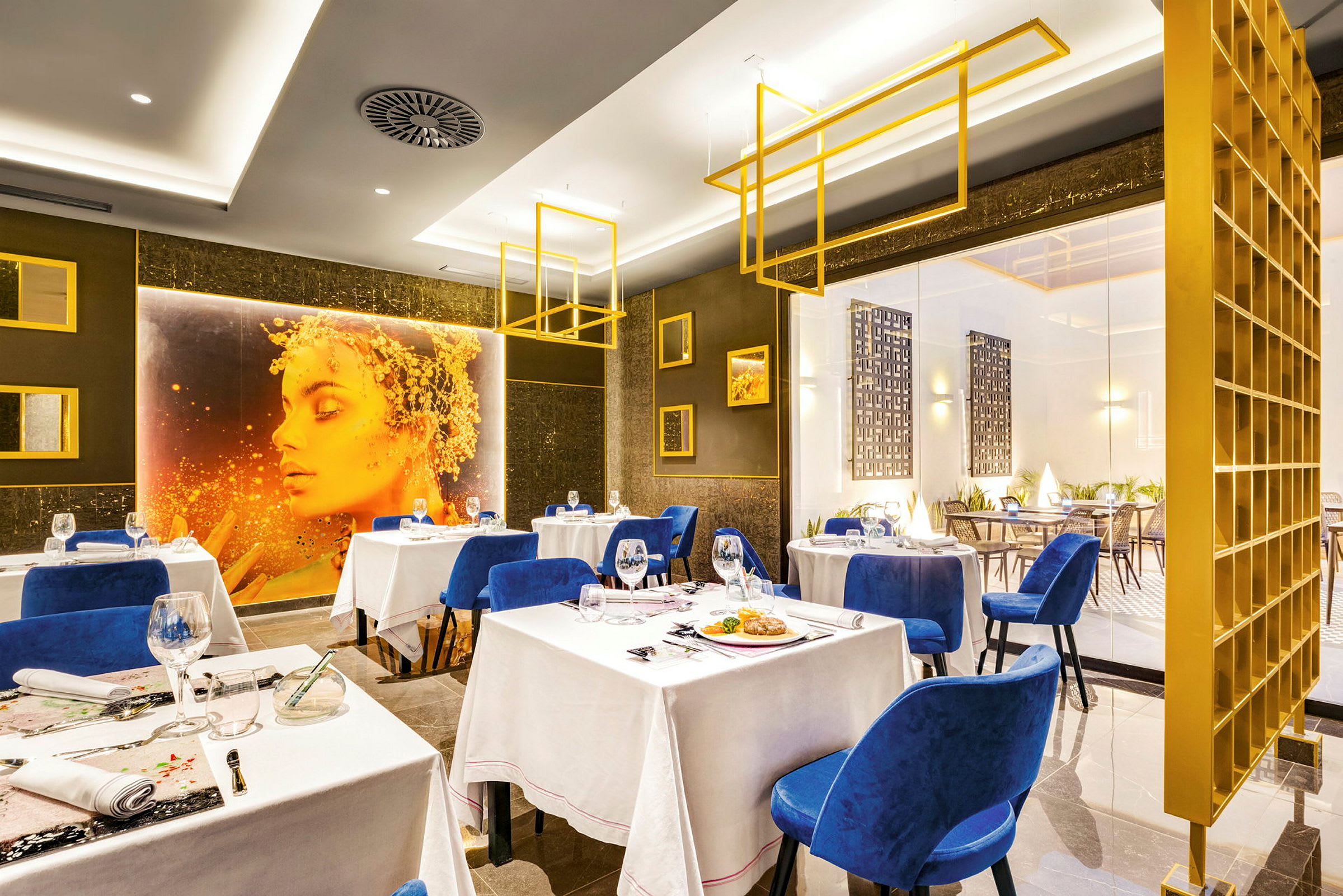 En elegant restaurant med blå stoler, hvite duker og moderne interiør. (AI-generert tekst)