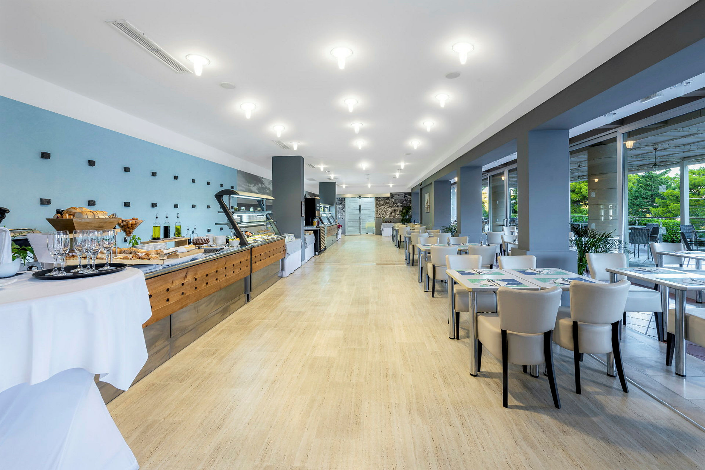 En lys og moderne restaurant med buffet til venstre og sitteplasser til høyre. (AI-generert tekst)