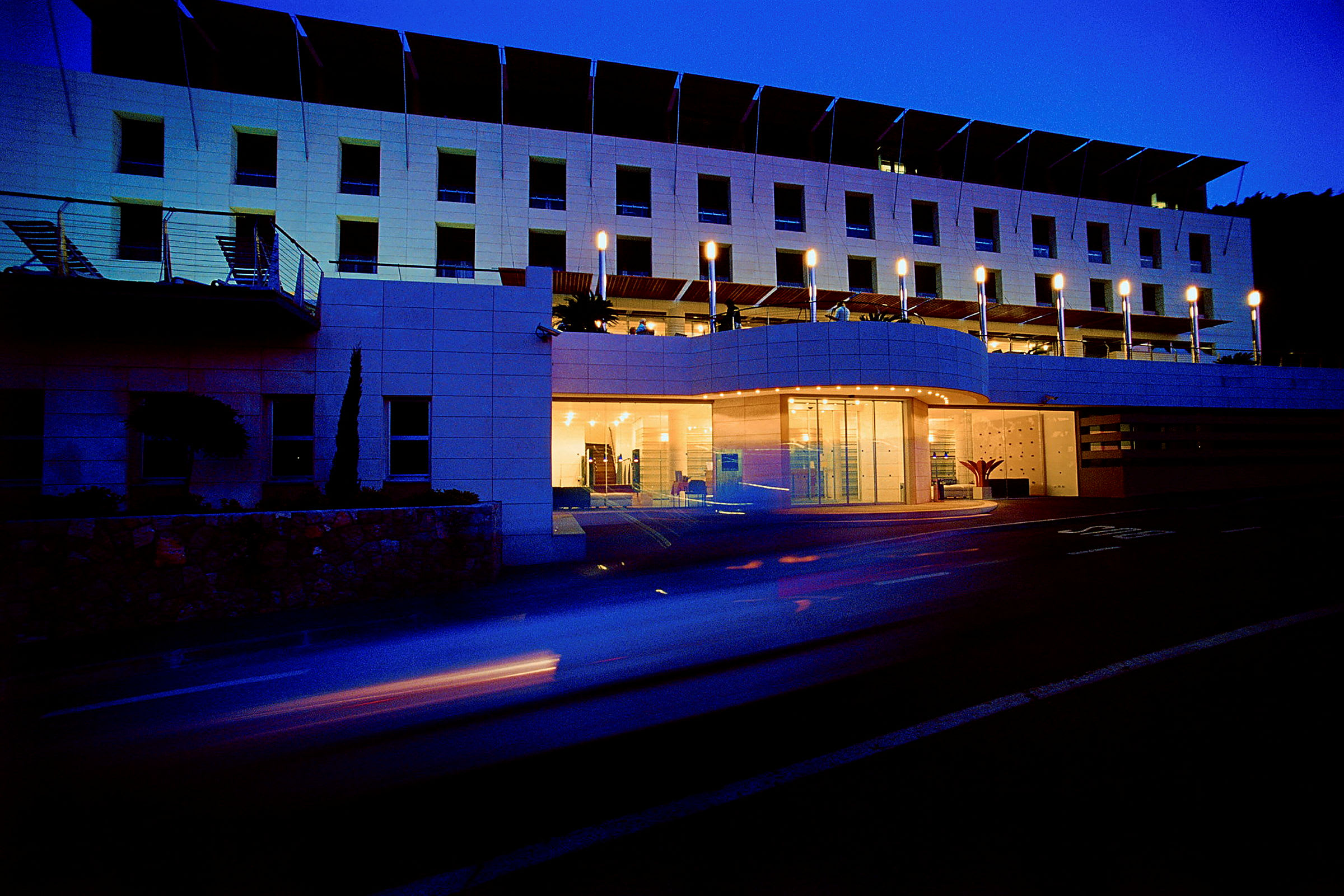Hotellfasade belyst i skumringen. (AI-generert tekst)