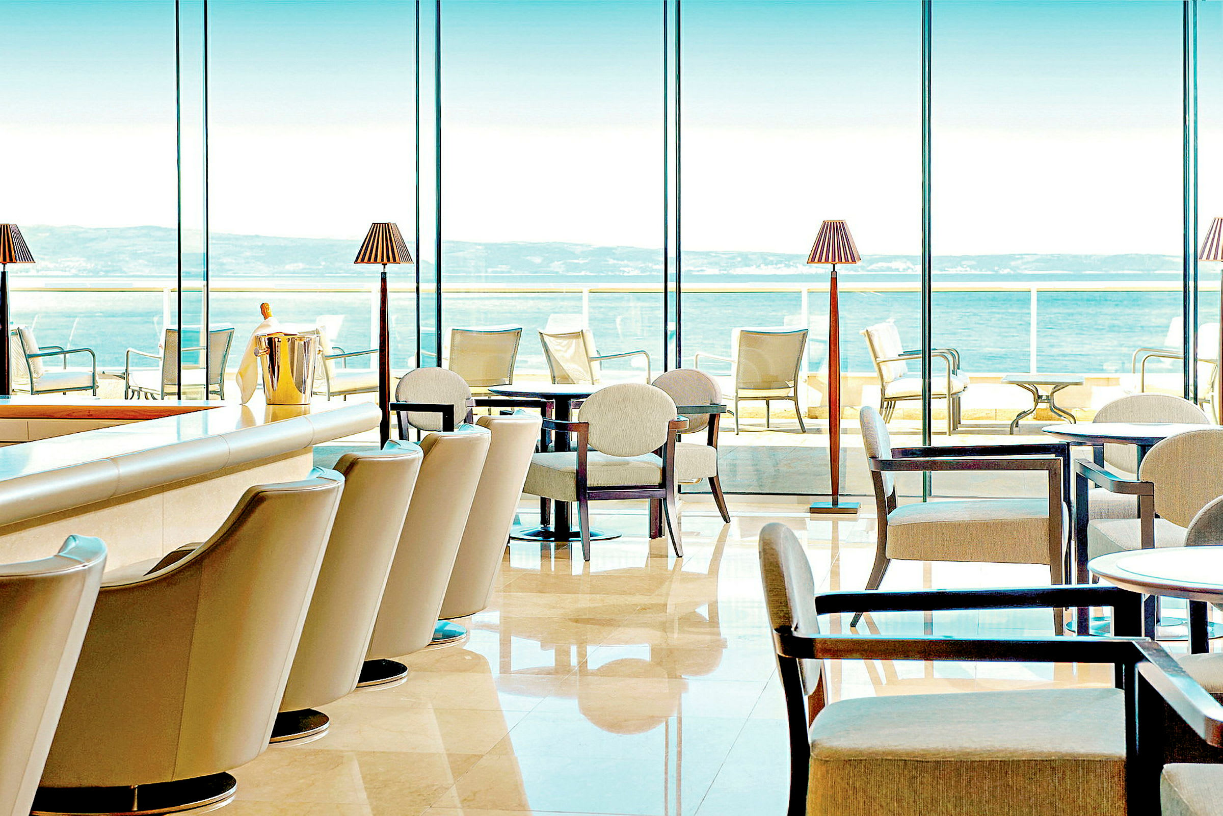 Restaurant med moderne møbler og store vinduer med utsikt over havet. (AI-generert tekst)