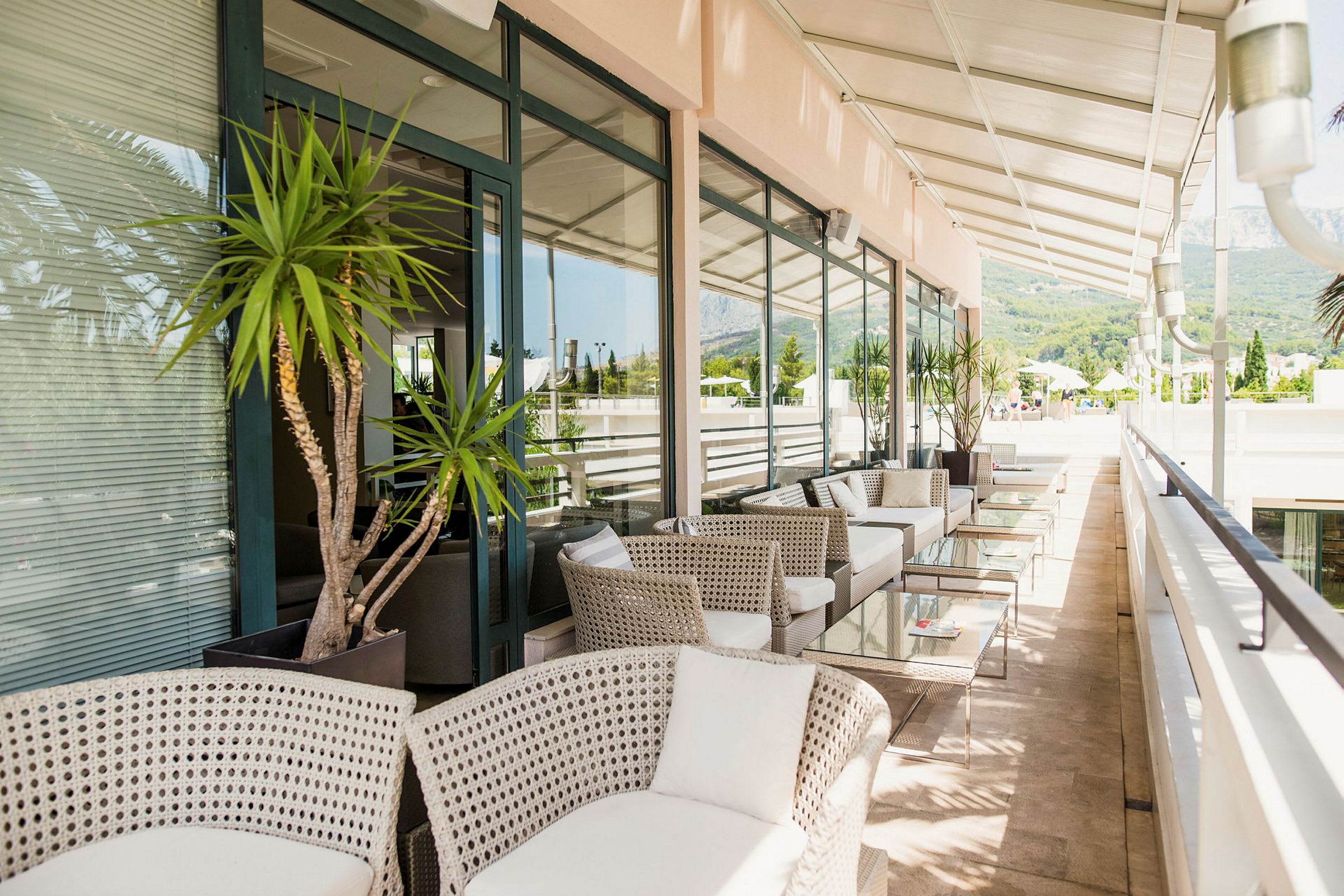 Terrasse med moderne møbler og glassbord under en pergola. (AI-generert tekst)