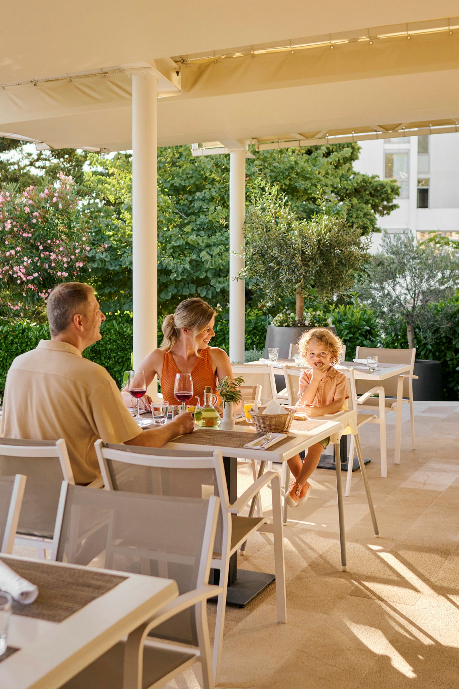 Personer sitter ved et bord på en restaurant i en utendørs miljø. (AI-generert tekst)