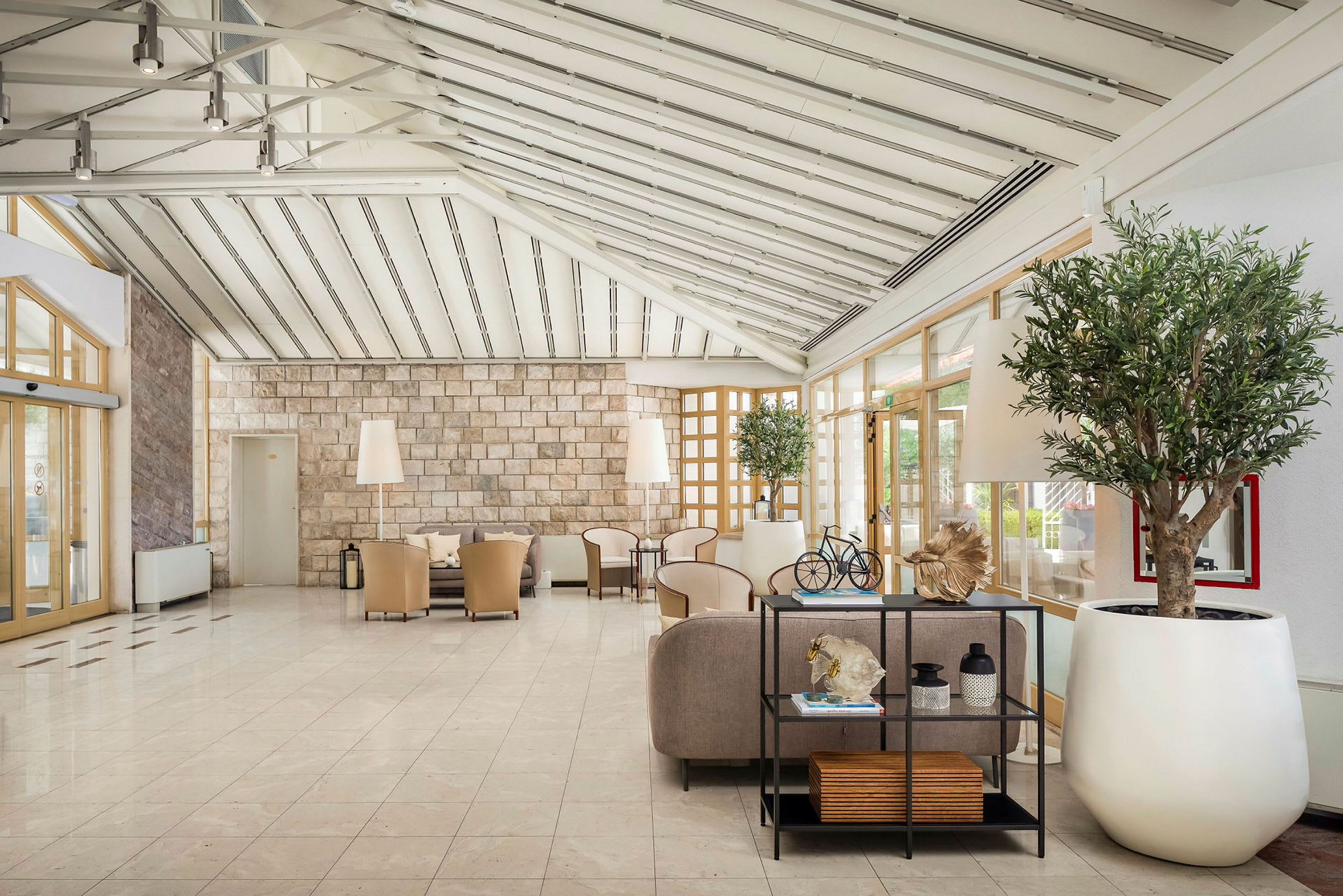 Lys og romslig hotellobby med sittegrupper og dekorative planter. (AI-generert tekst)