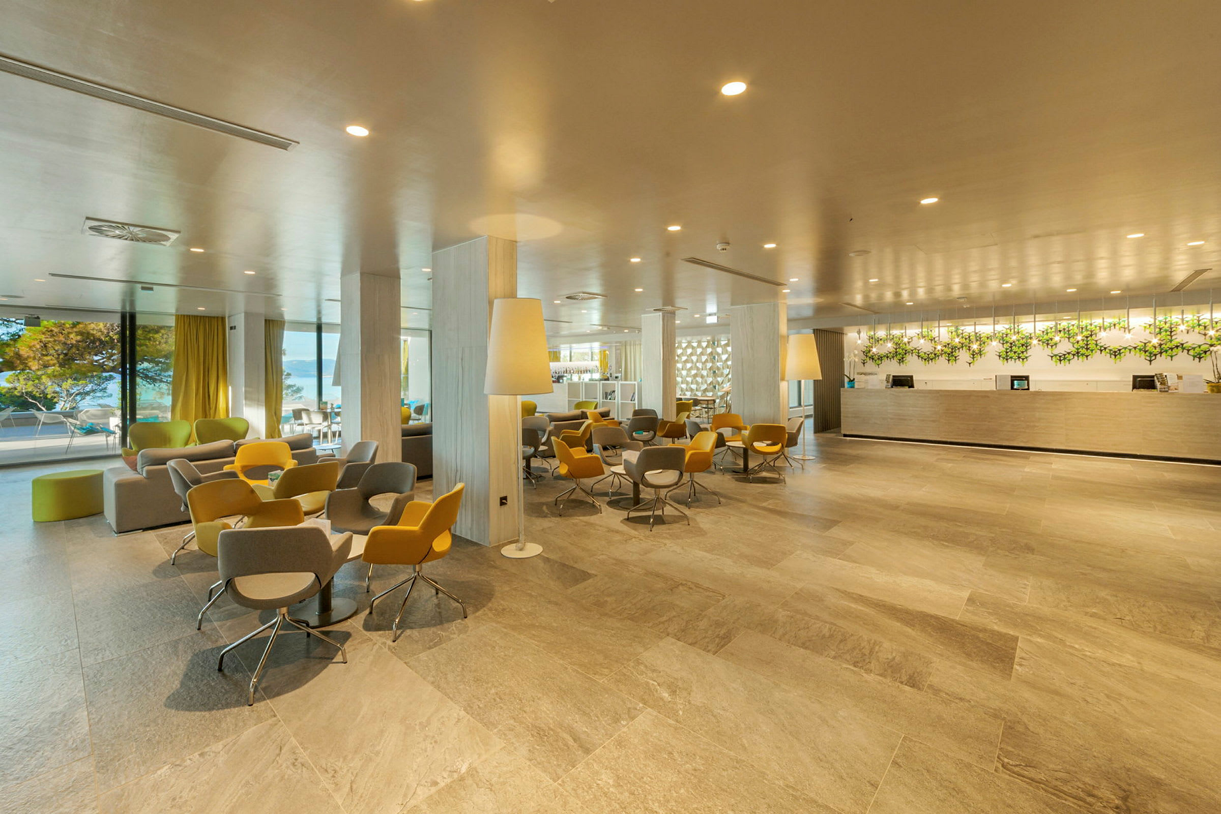Hotellets lobby med resepsjon og sitteområder i moderne interiør. (AI-generert tekst)