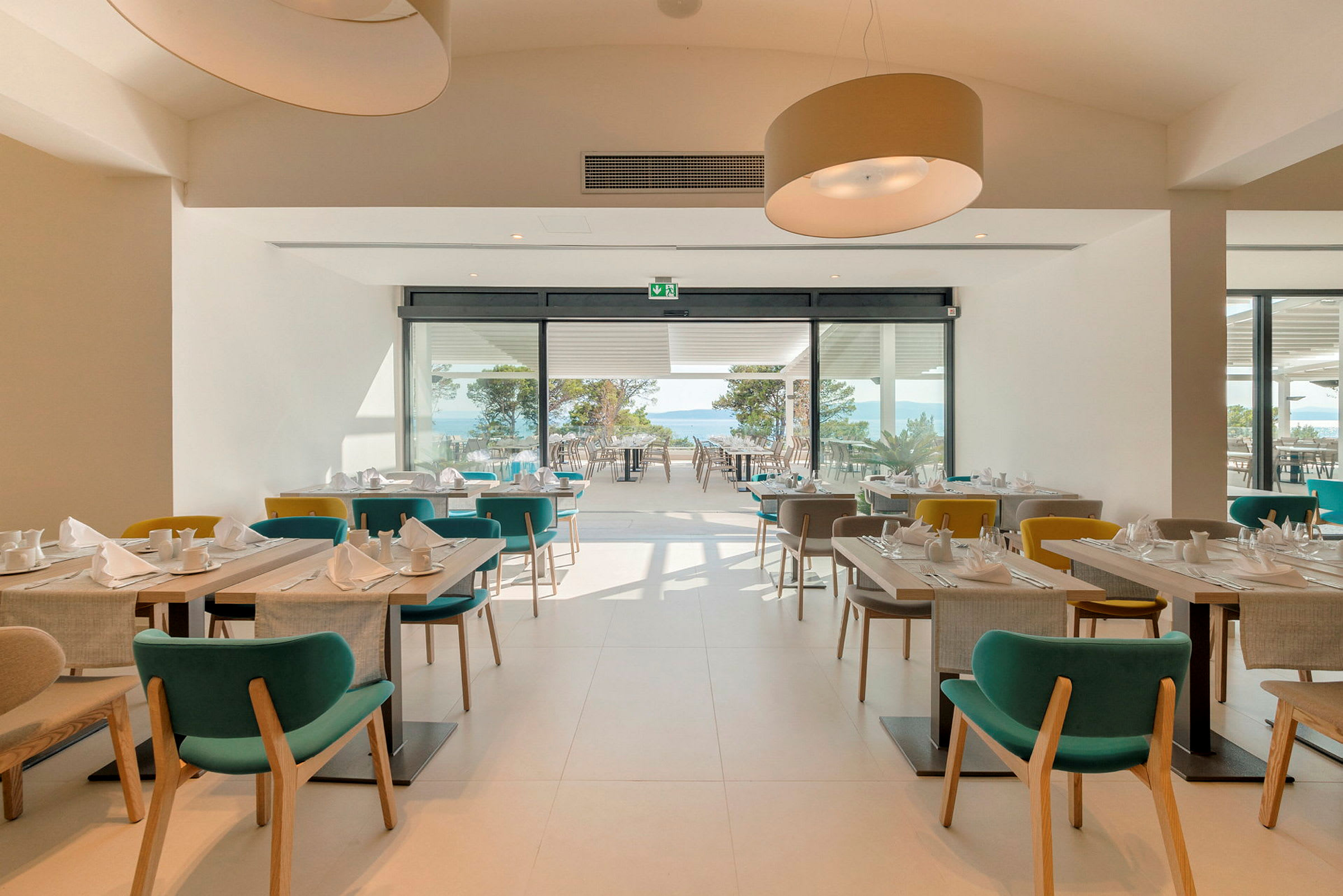 En moderne restaurant med store vinduer og havutsikt. (AI-generert tekst)