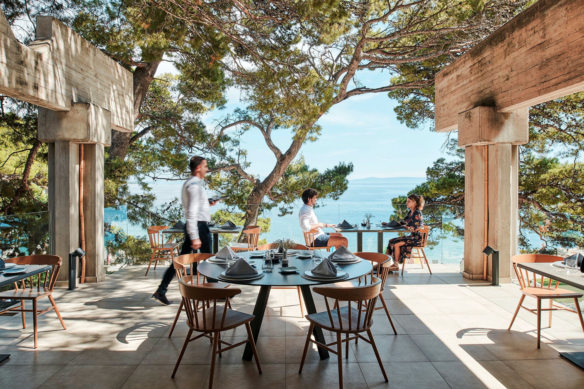 Restaurant på en terrasse med utsikt over havet. (AI-generert tekst)