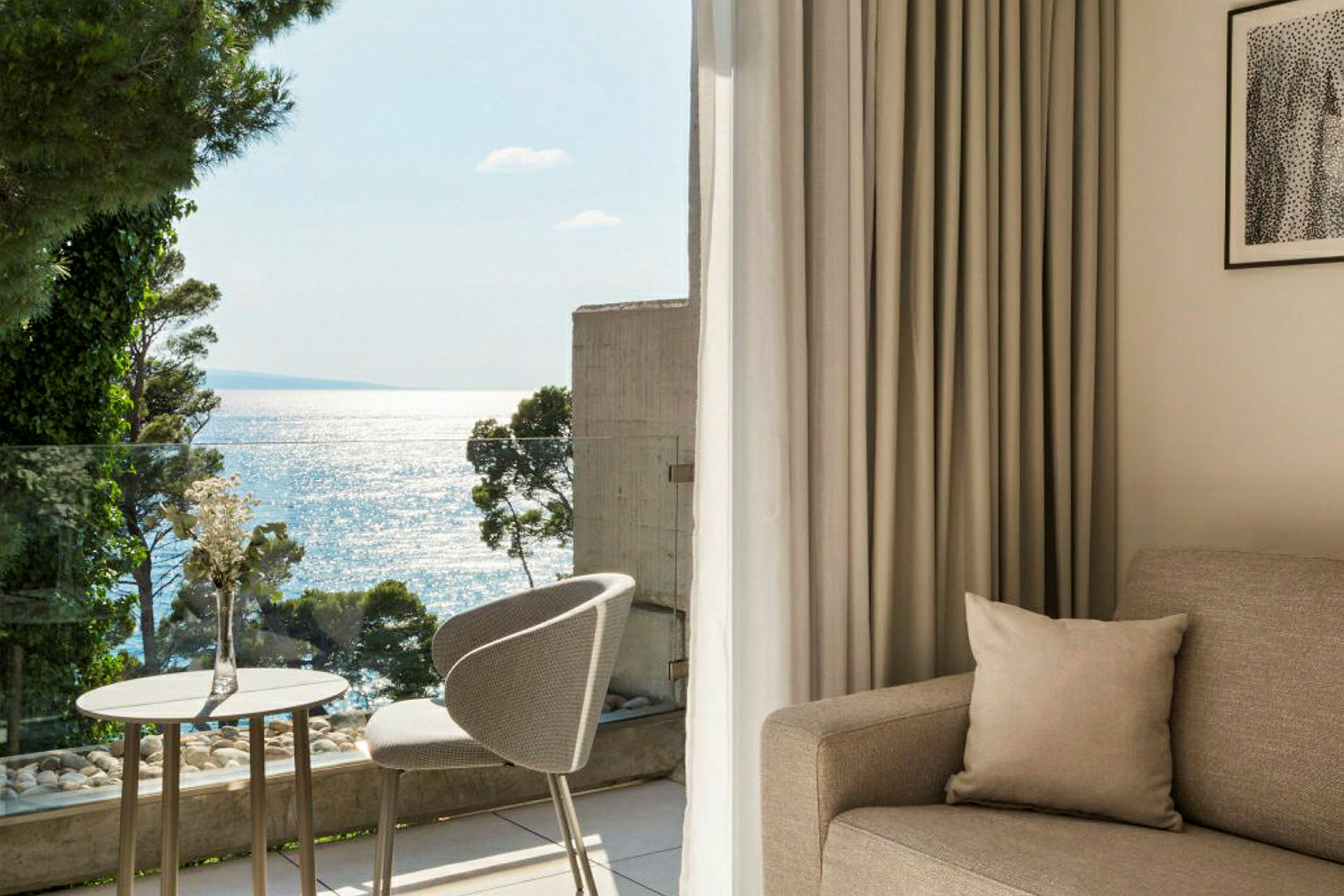 Lyst og moderne hotellrom med havutsikt fra balkongen. (AI-generert tekst)