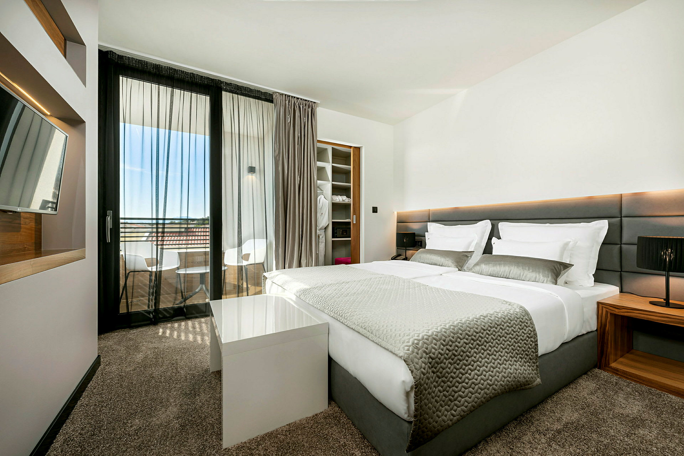 Moderne hotellrom med dobbeltseng og balkong. (AI-generert tekst)