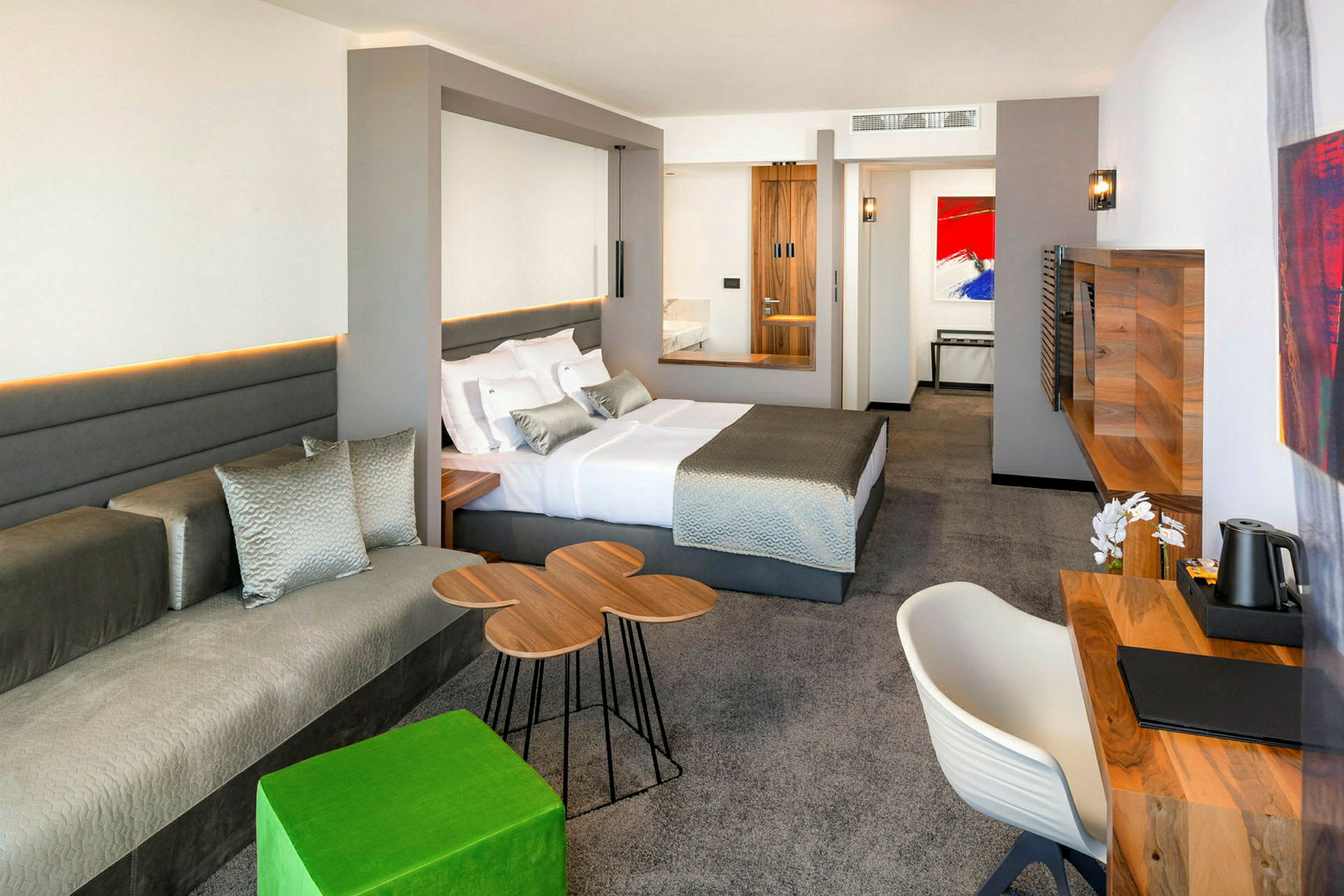Moderne hotellrom med en stor seng, skrivebord og sittegruppe. (AI-generert tekst)