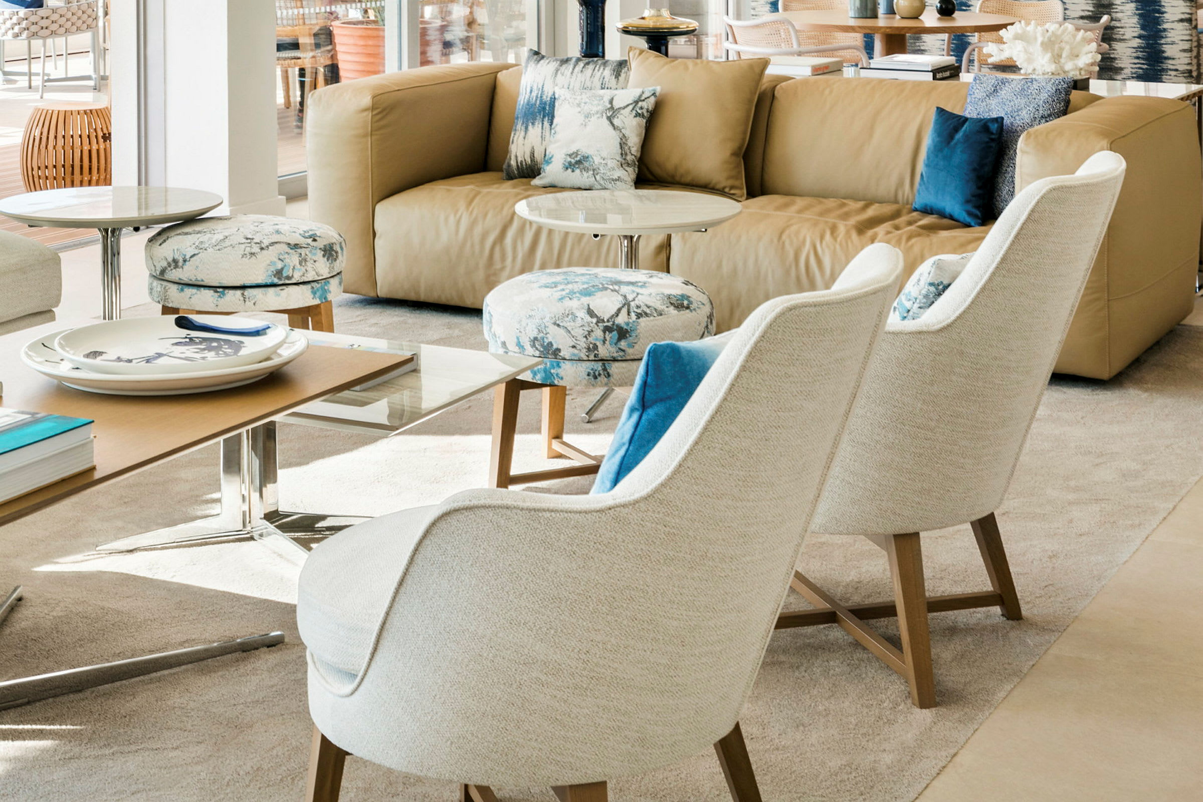 En moderne stue med en beige sofa, to hvite lenestoler og et salongbord. (AI-generert tekst)